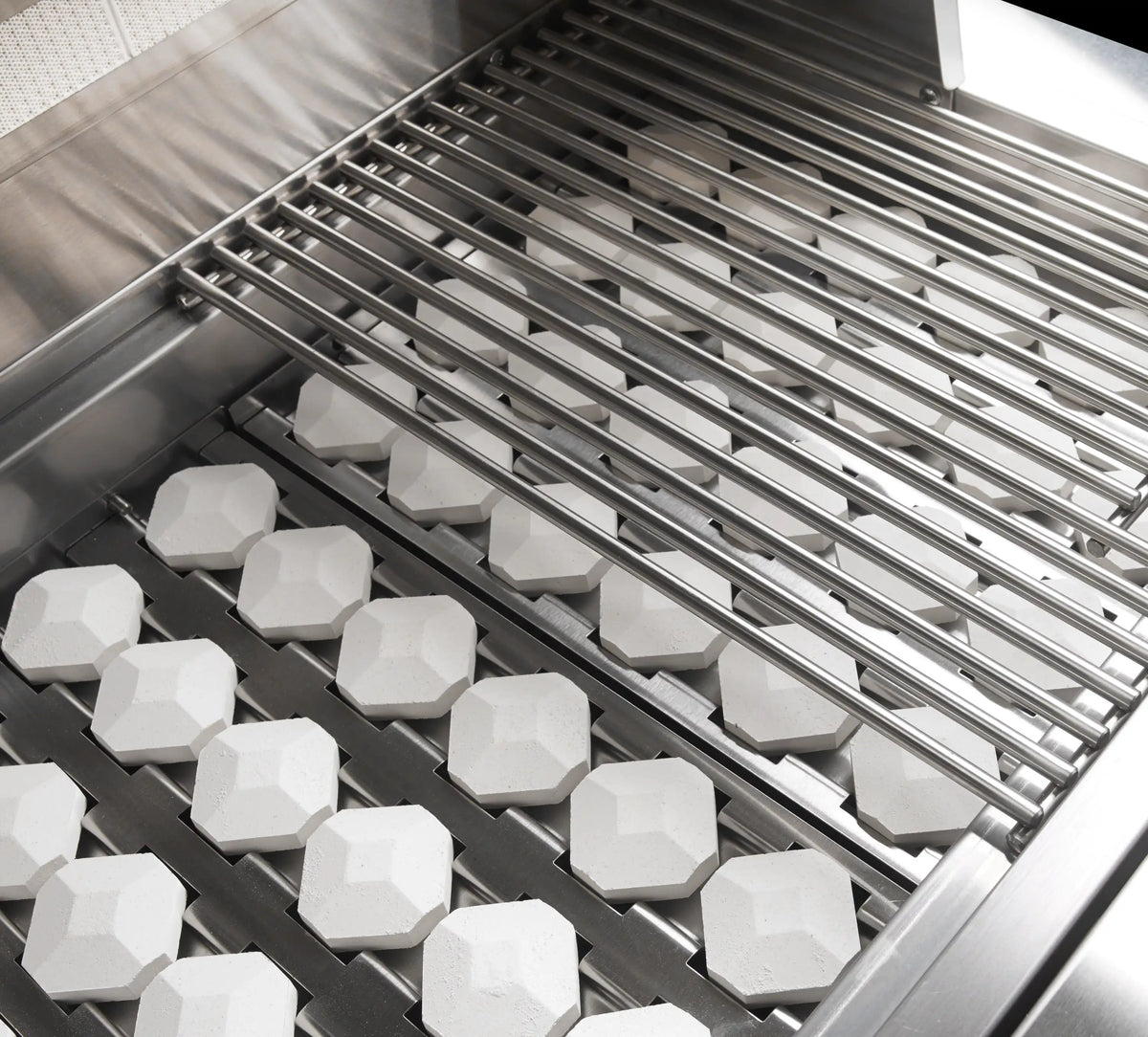 Stainless steel grill firebox with hex ceramic briquettes and stainless cooking grate