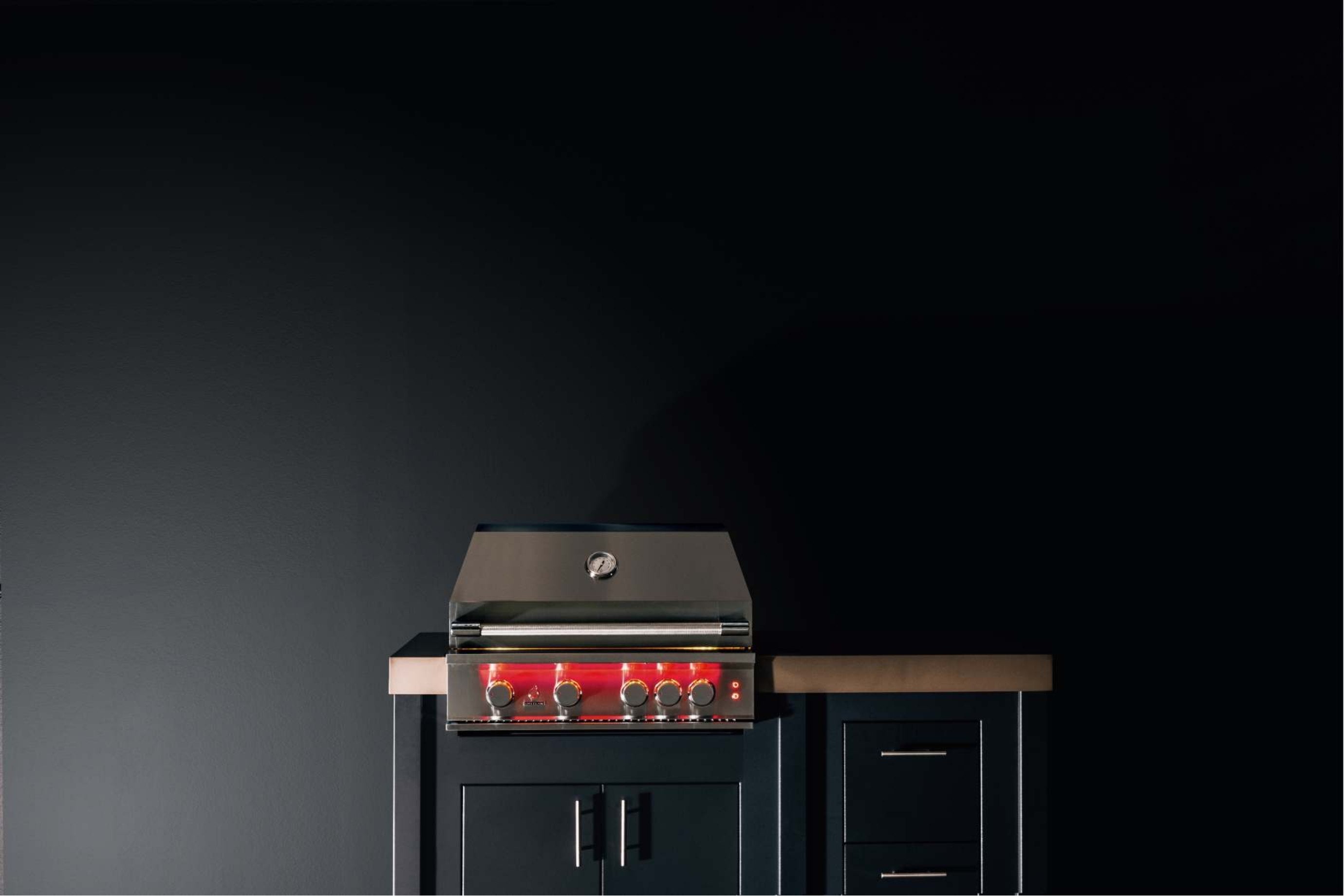 Stainless steel built-in propane gas grill with open hood and front burner controls