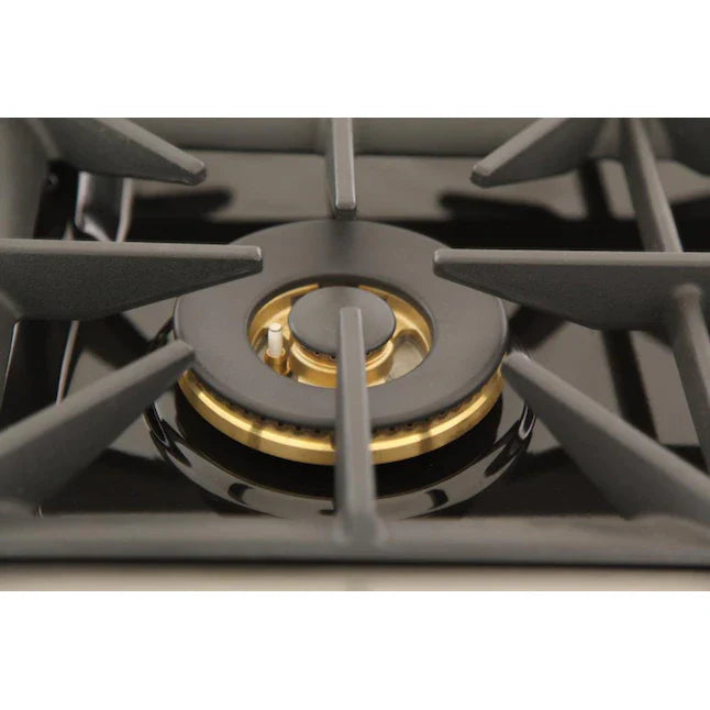 Gas cooktop burner with gold ring detail and black cast iron grates.