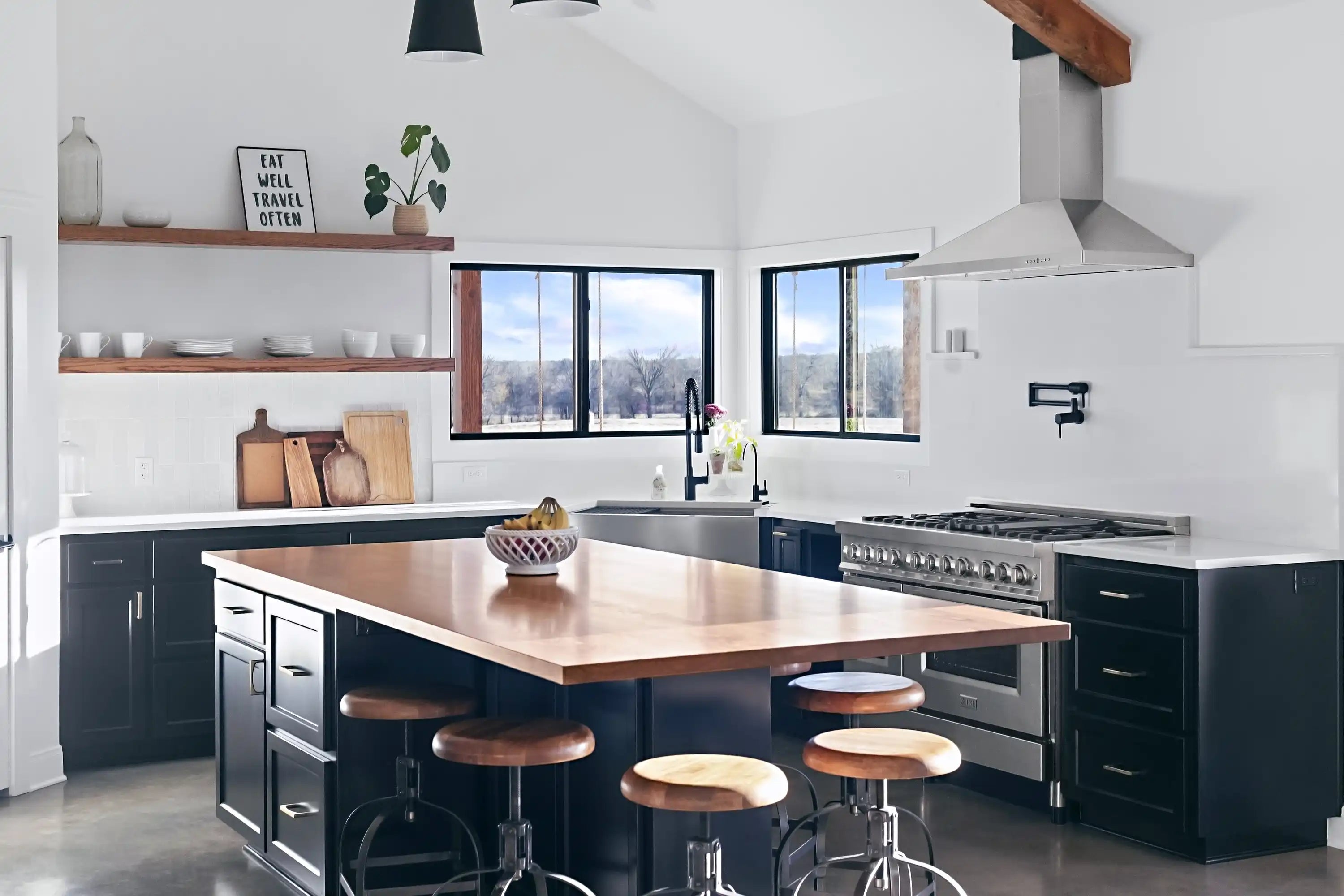 Stainless steel wall-mount range hood above a cooktop in a modern kitchen