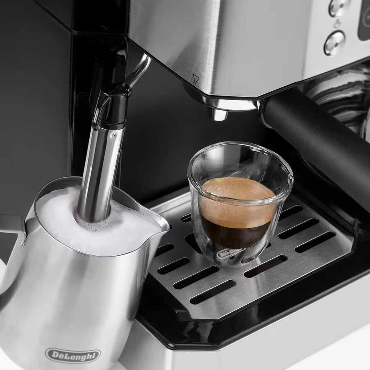 Close-up of De'Longhi espresso machine steam wand over espresso cup