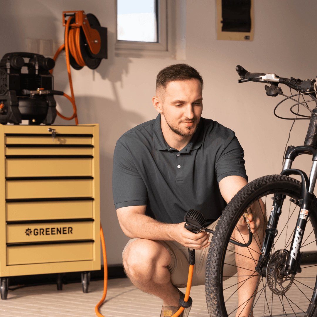 Orange retractable air hose reel with extended hose in workshop