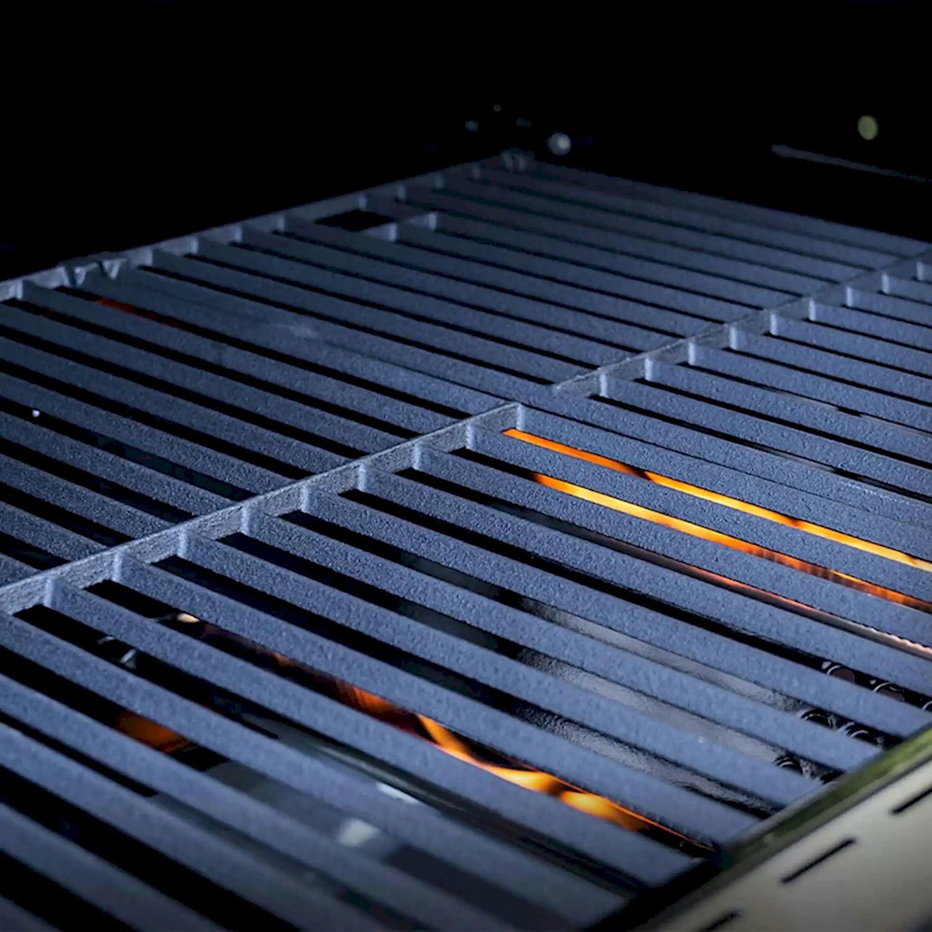 Infrared grill grates with glowing burner bars across the cooking surface