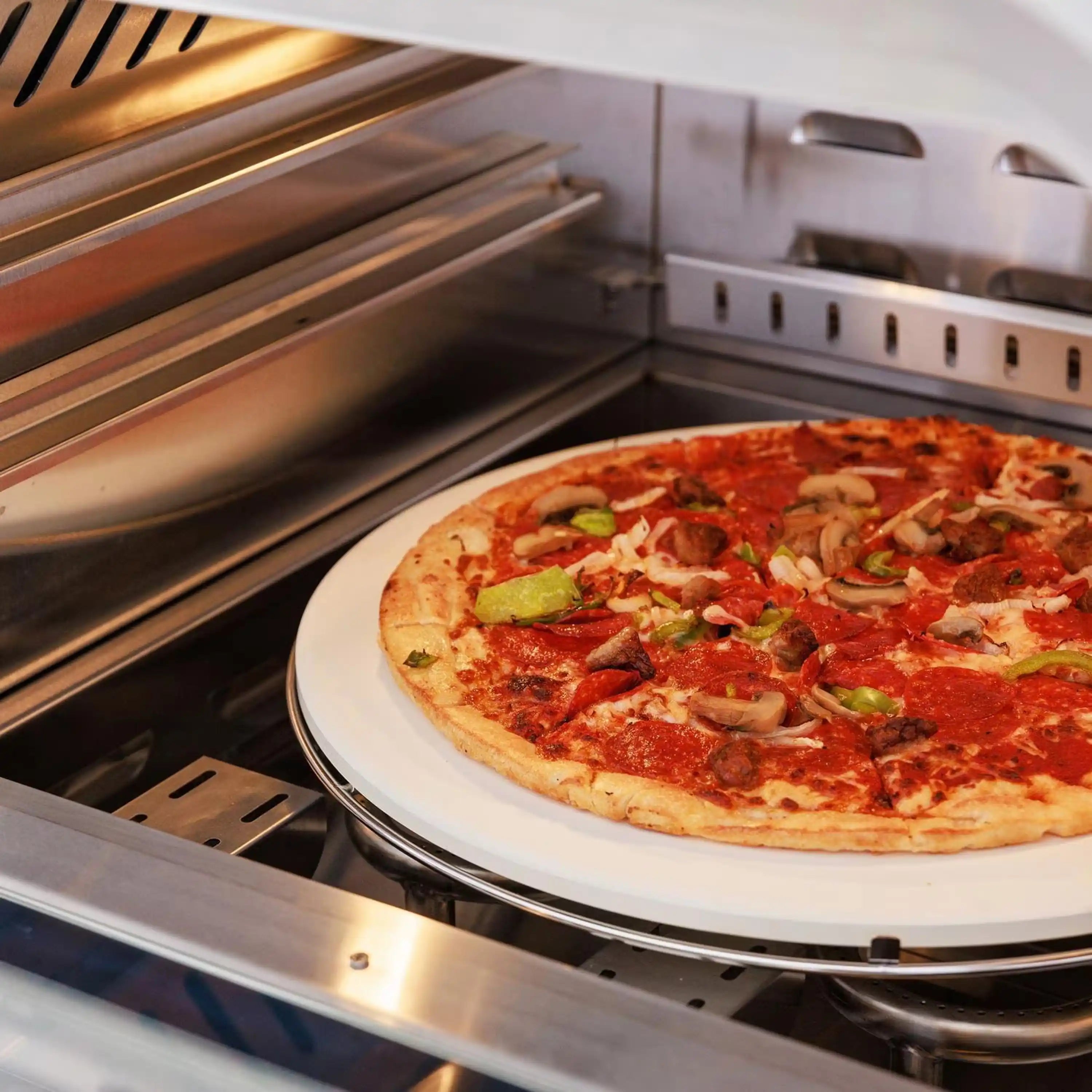 Open stainless steel propane pizza oven with pizza on round stone inside