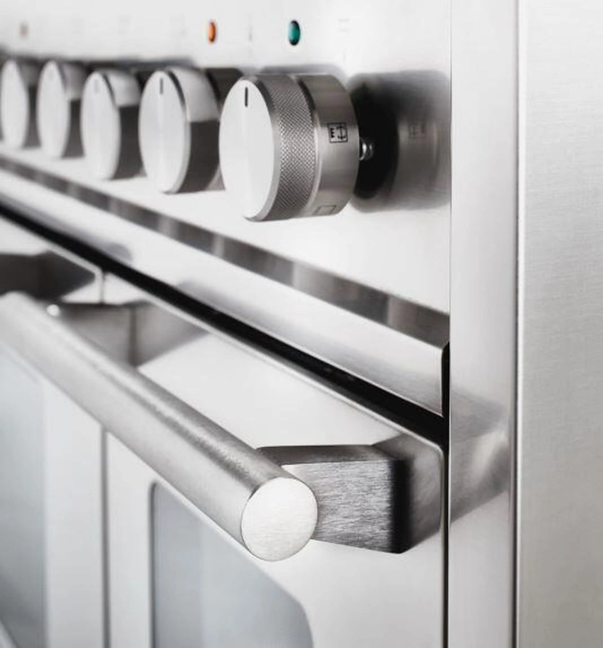 Stainless oven control panel with large black knob and brushed metal trim
