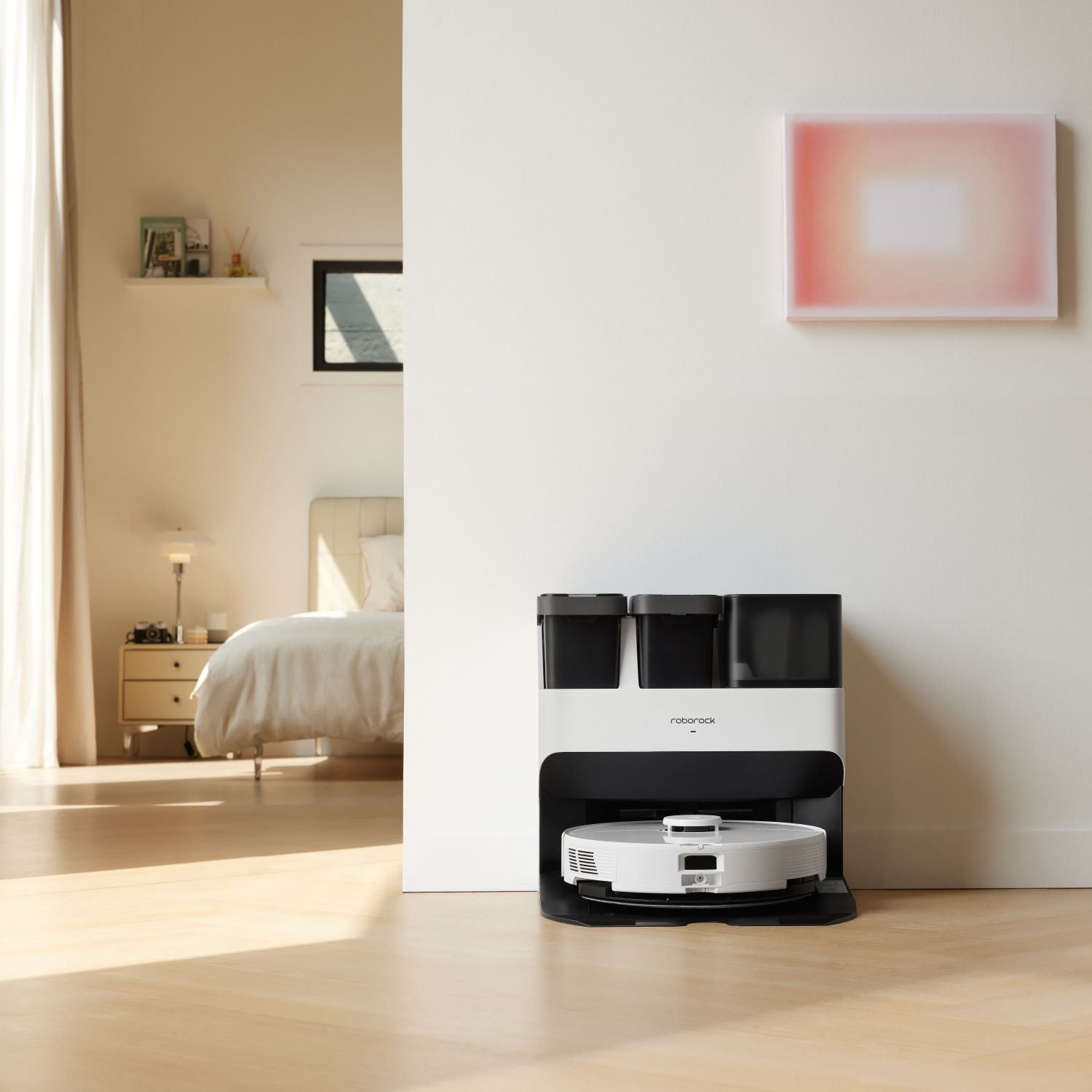 Robot vacuum dock in white base with two black tanks and a charging compartment