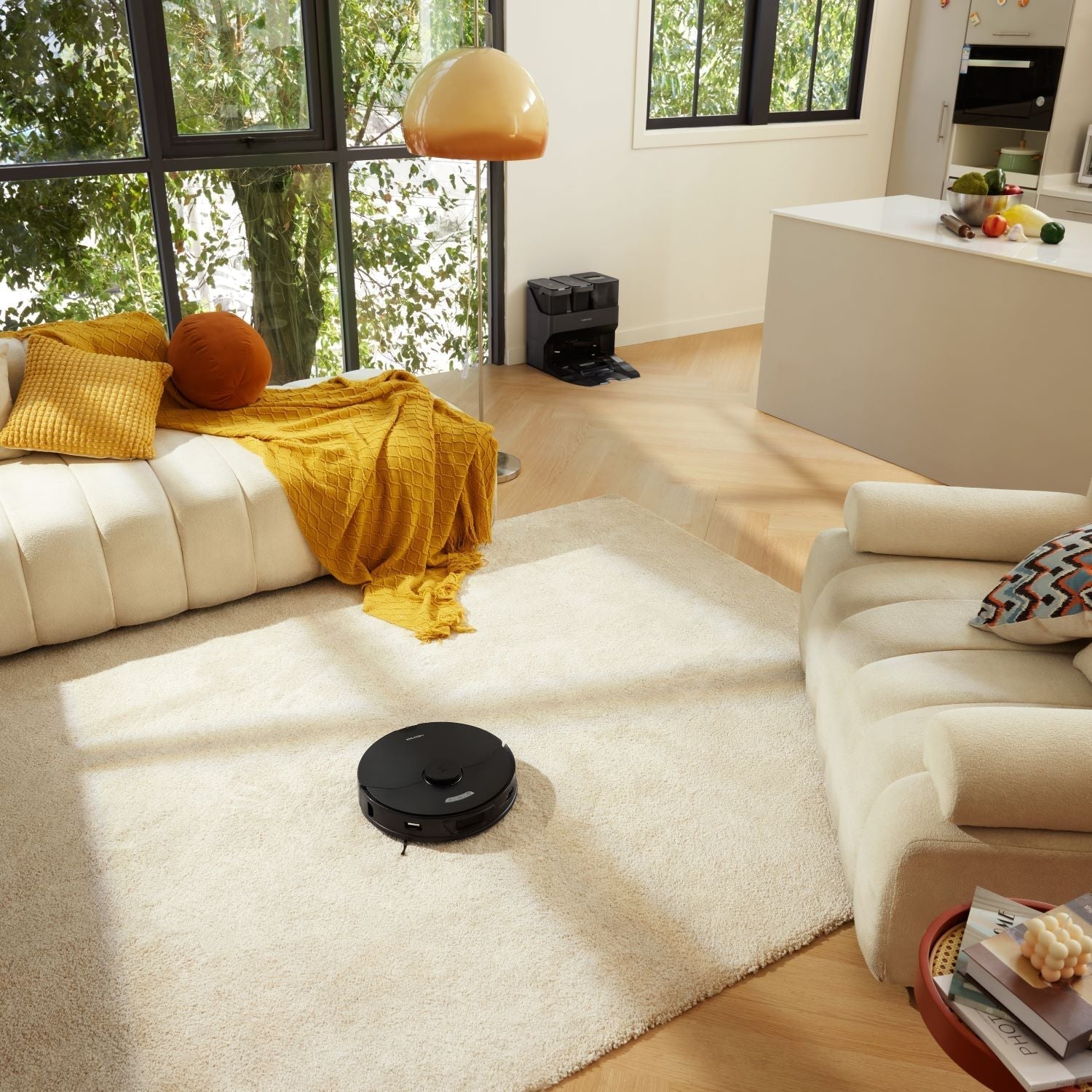 Robot vacuum on beige carpet near sofa, compact round body with top control area
