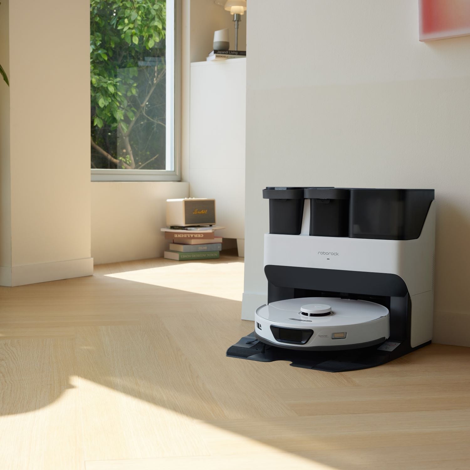 Robot vacuum docked at charging station with lifted mopping tanks above
