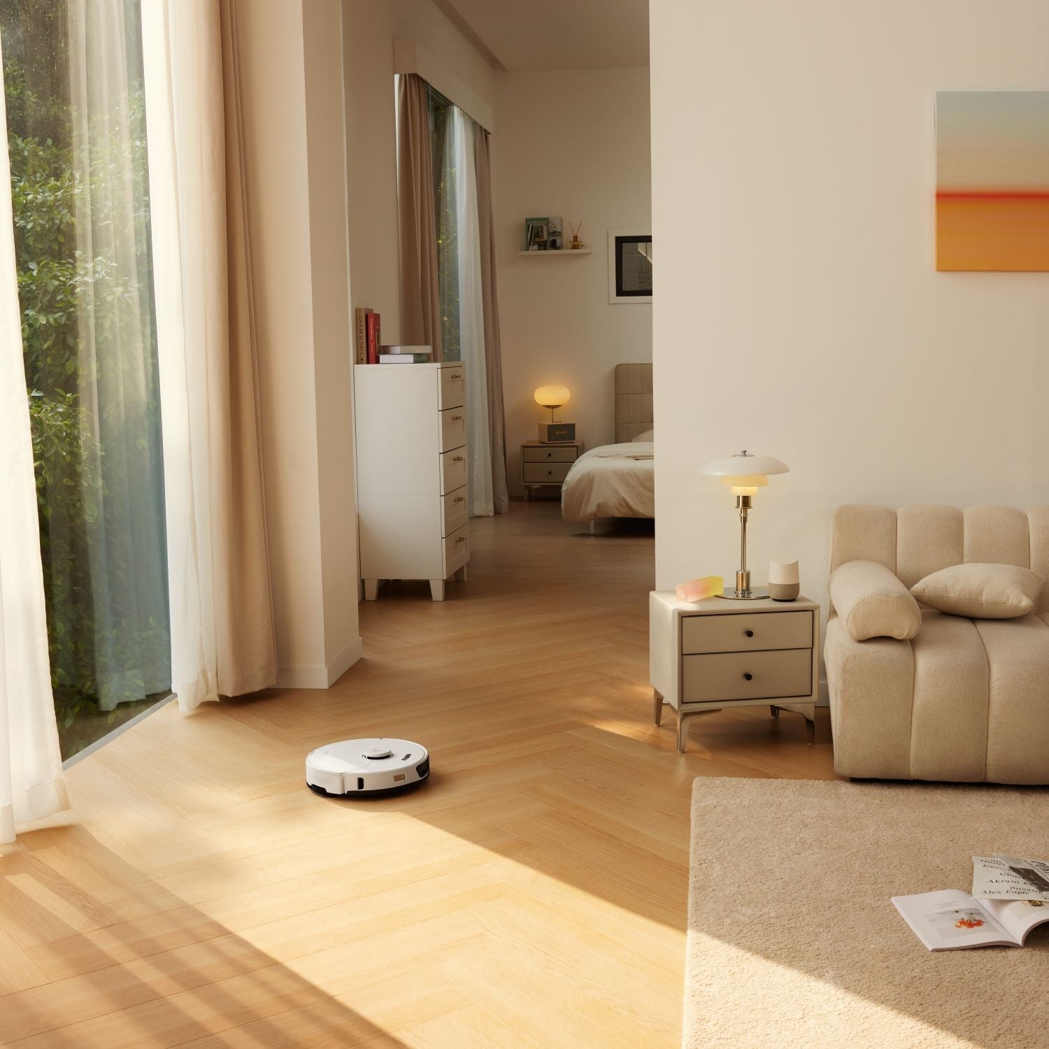 White robot vacuum on wood floor near sofa and open charging station