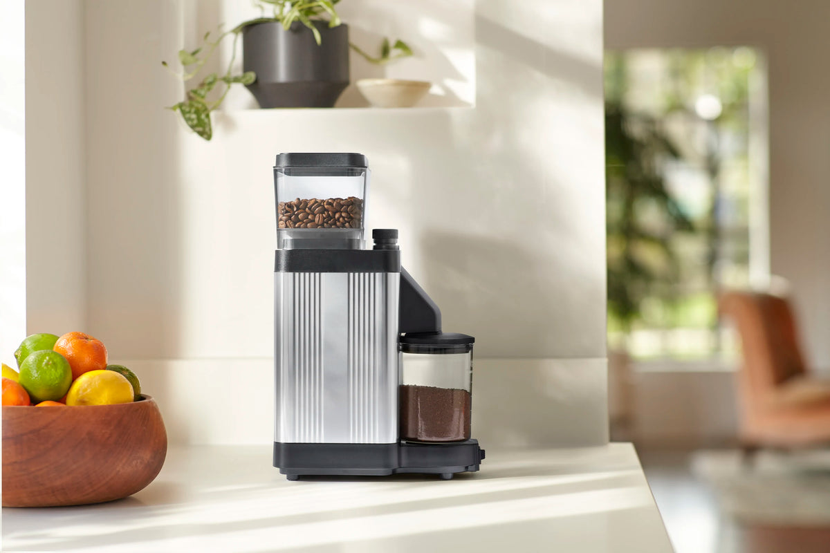 Polished silver burr grinder with transparent hopper and black side catch bin