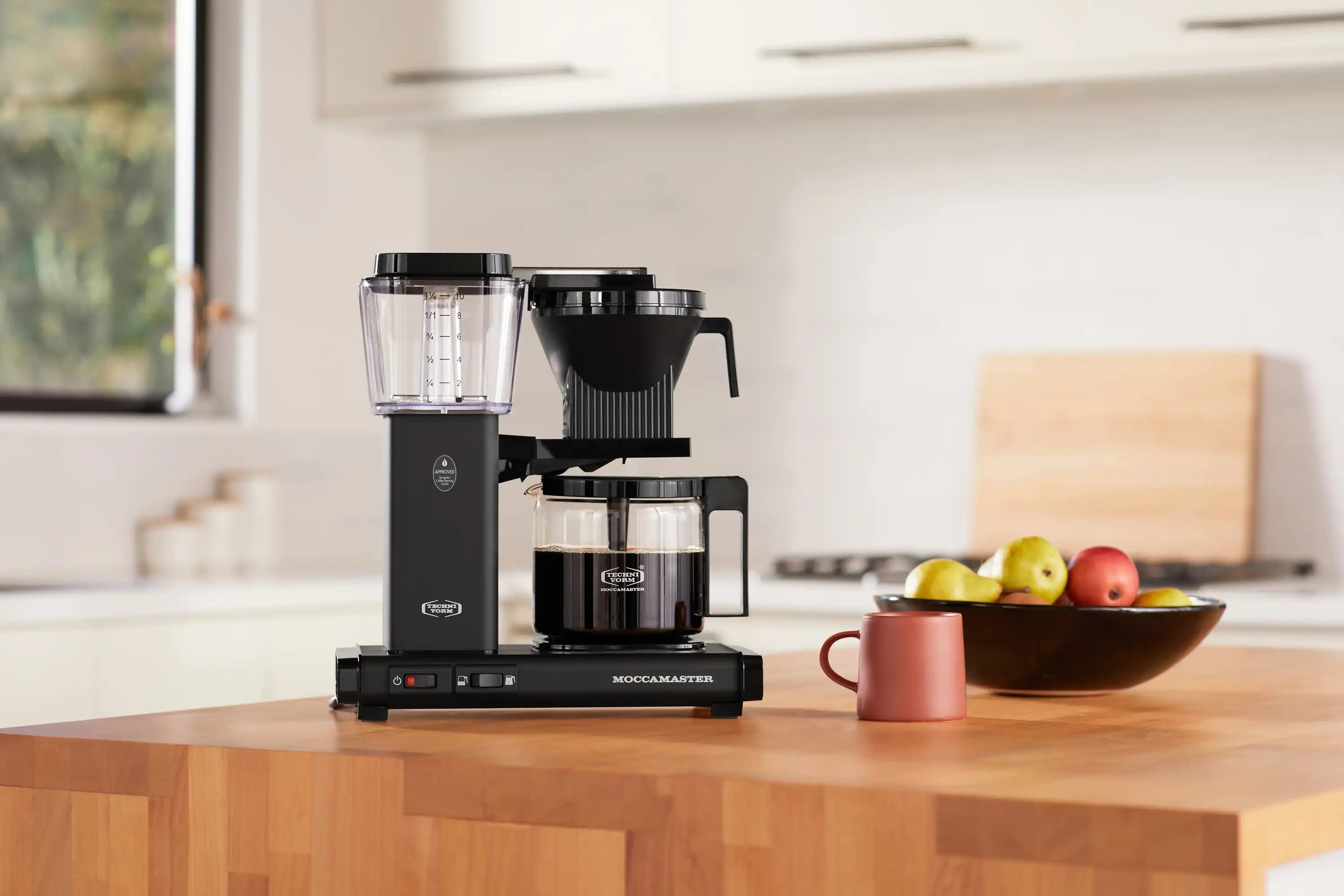 Moccamaster matte black coffee maker with glass carafe and front controls visible