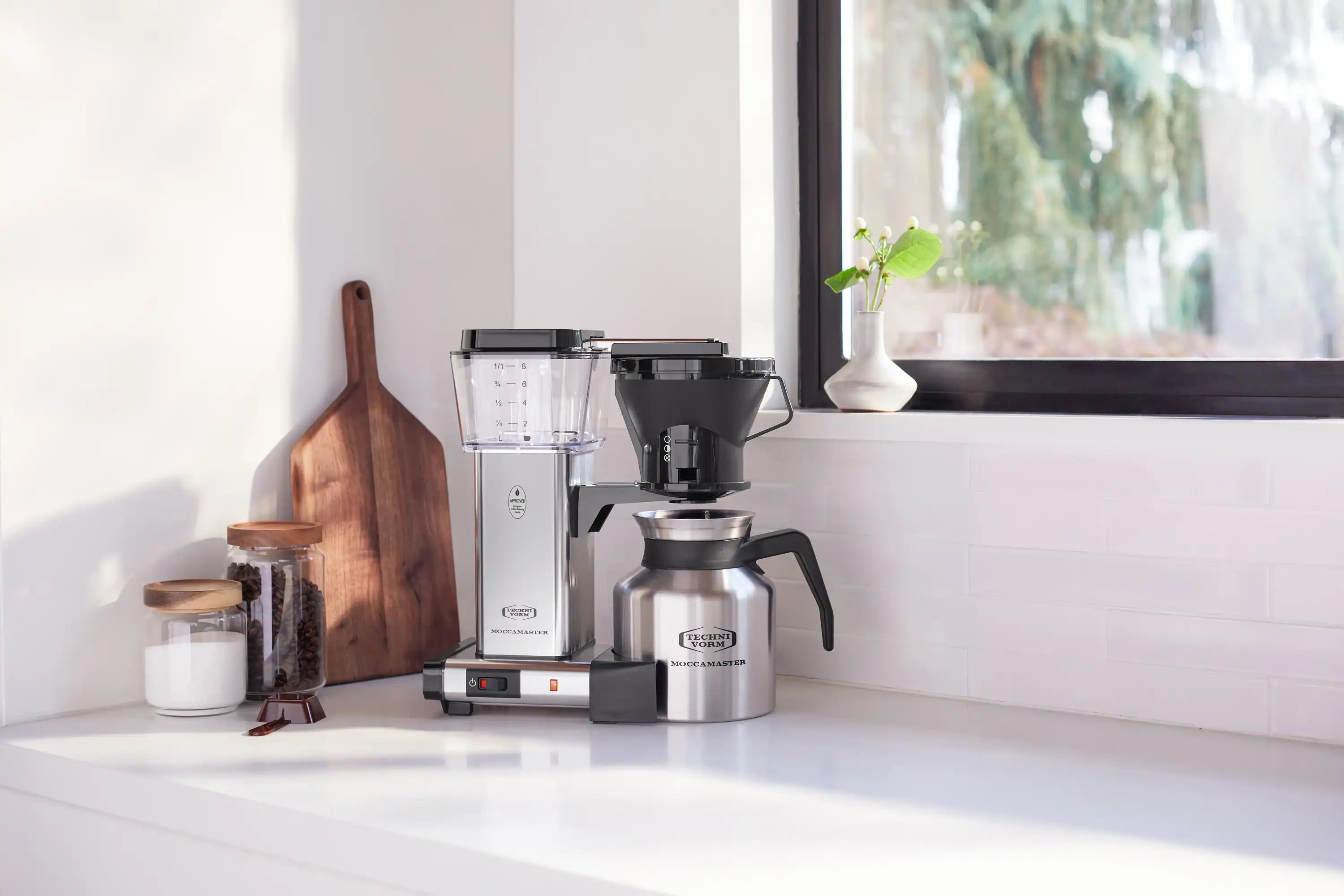 Silver and black coffee maker with thermal carafe and side handle reservoir