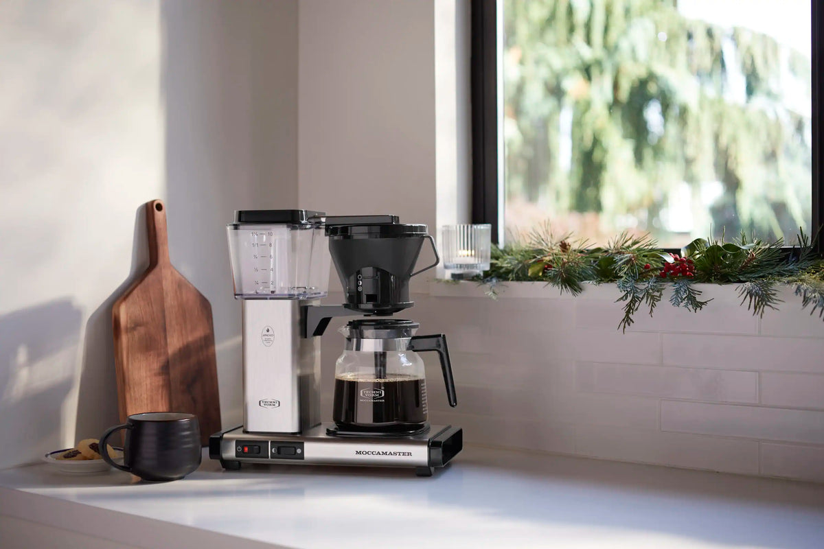 Brushed silver and black thermal carafe coffee maker on kitchen counter with carafe