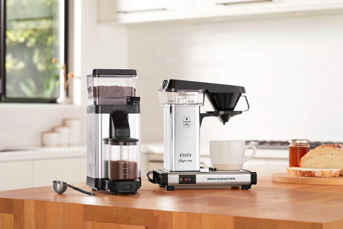 Polished silver burr grinder with transparent hopper and black feed chute