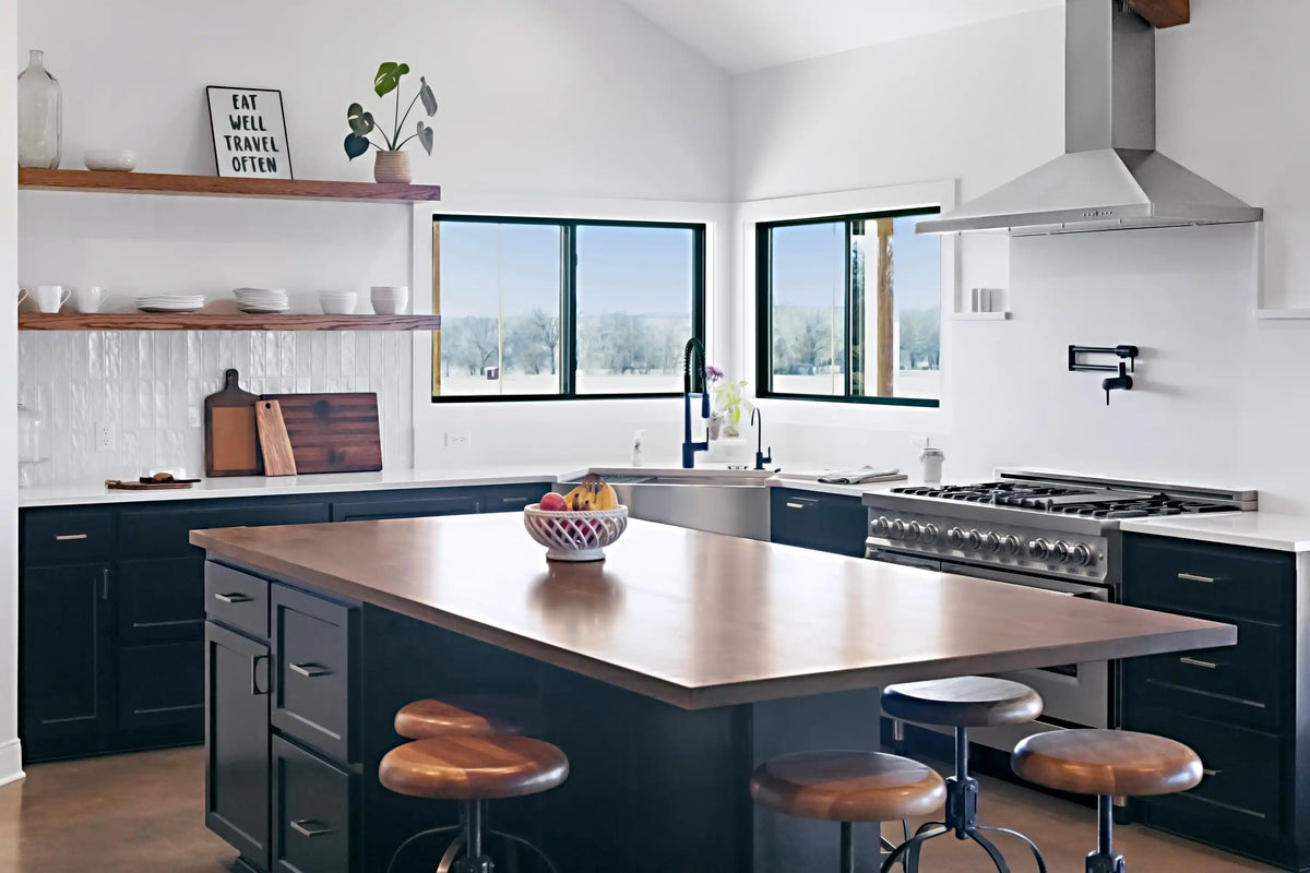 Stainless steel wall-mount range hood with chimney over a gas cooktop