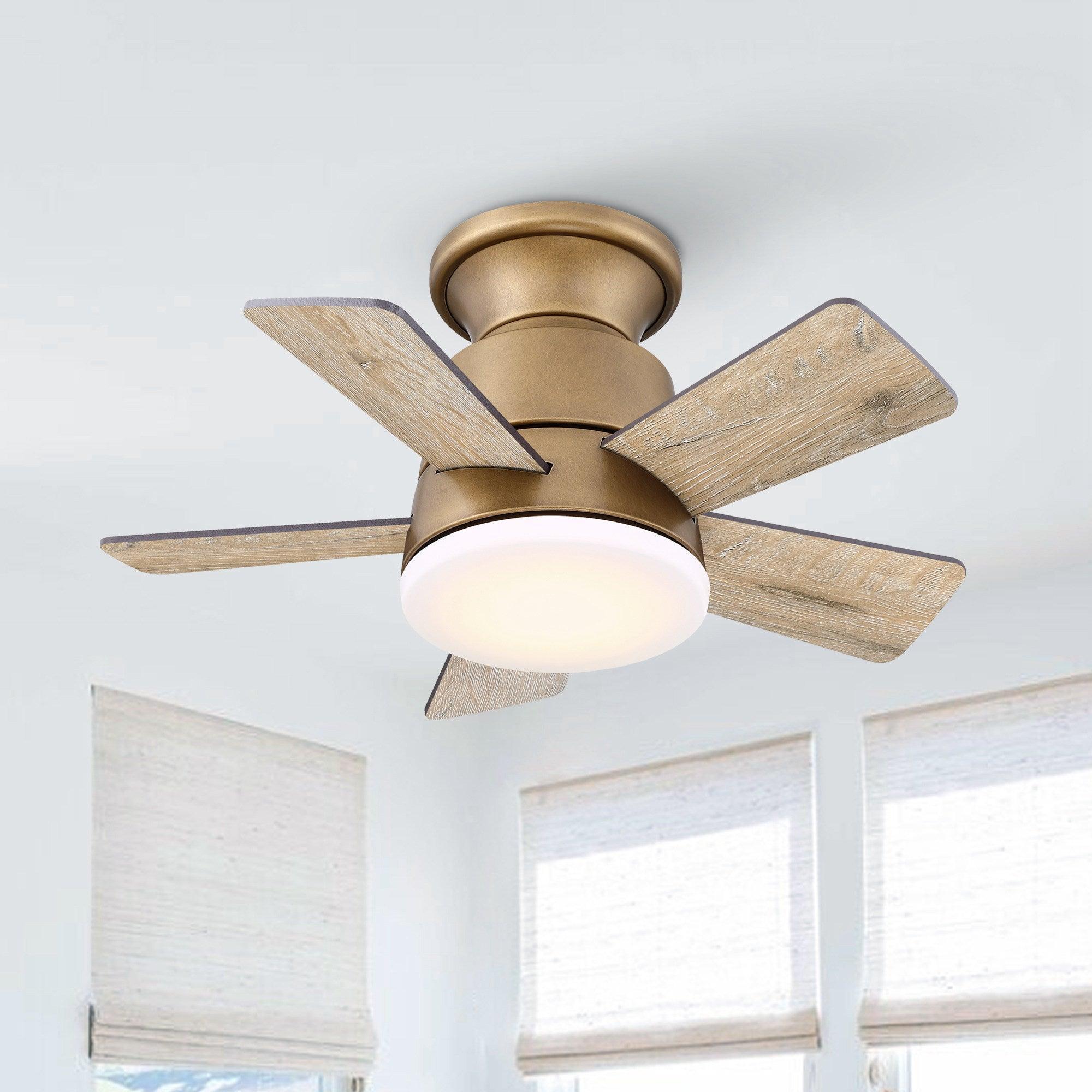 Brushed brass flush mount ceiling fan with reversible wood-look blades and frosted light