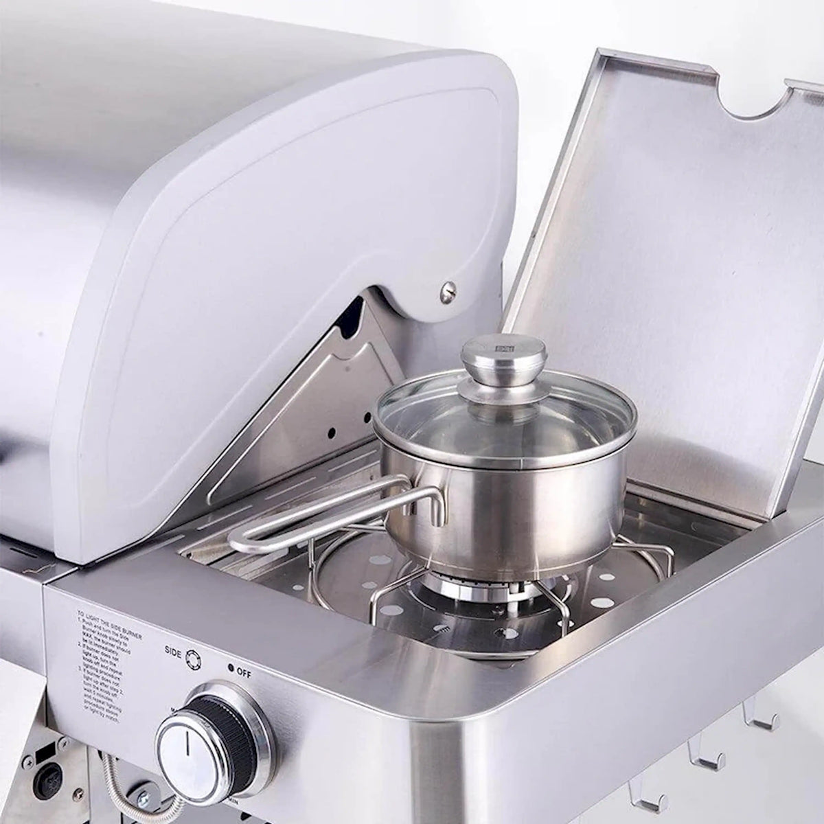 Stainless steel side burner with a lidded pot on the burner grate