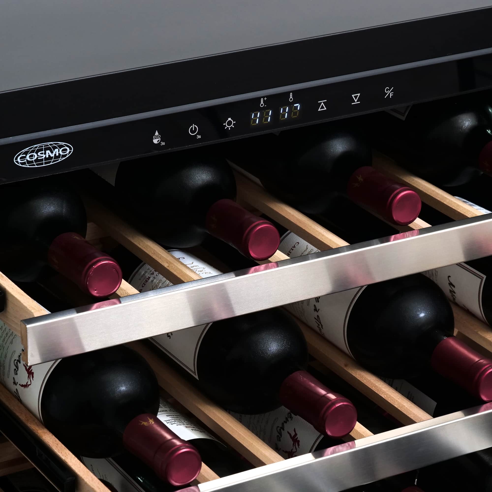Stainless steel wine cooler interior with wooden shelves and red wine bottles