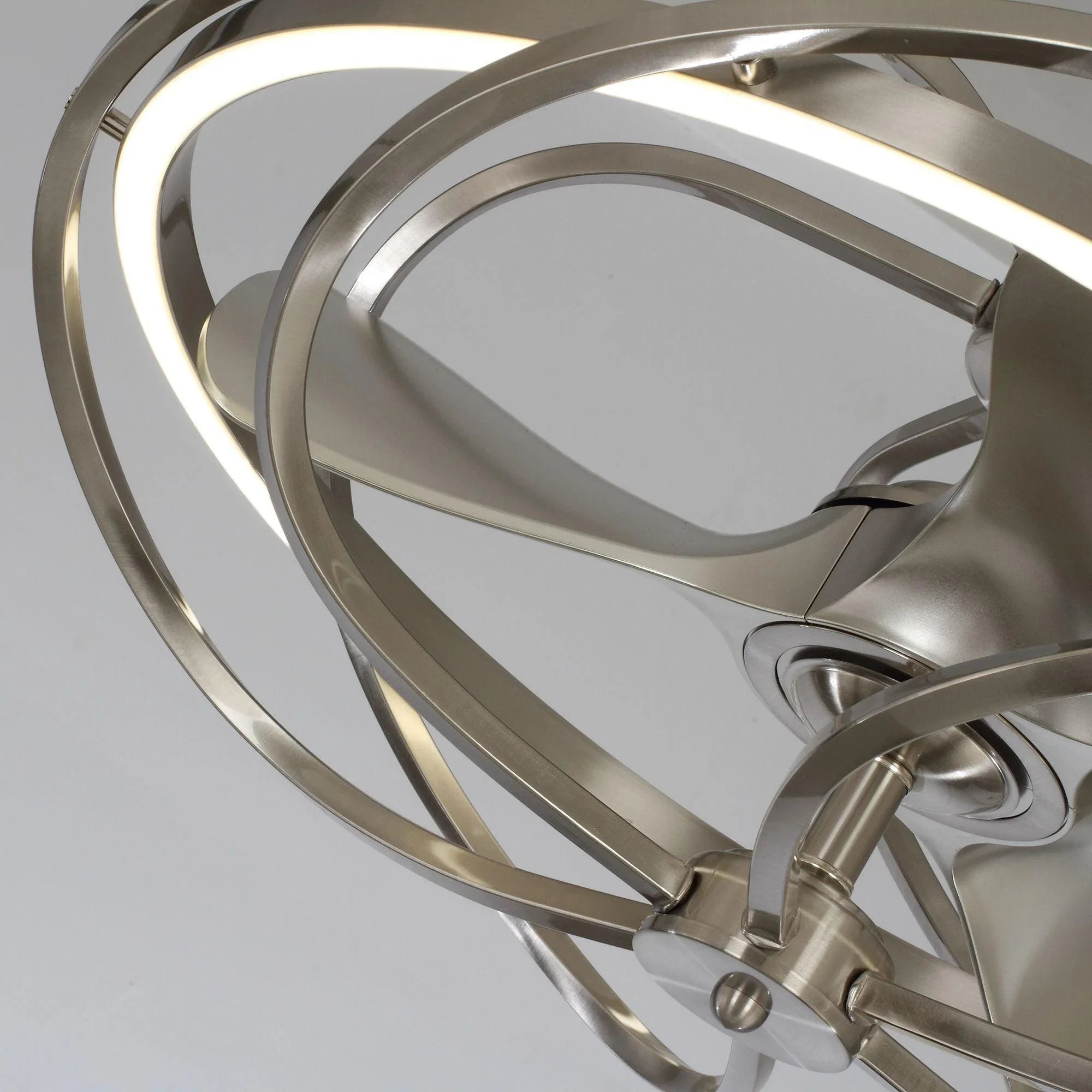 Close-up of illuminated brushed nickel ceiling fan light ring and blade hub
