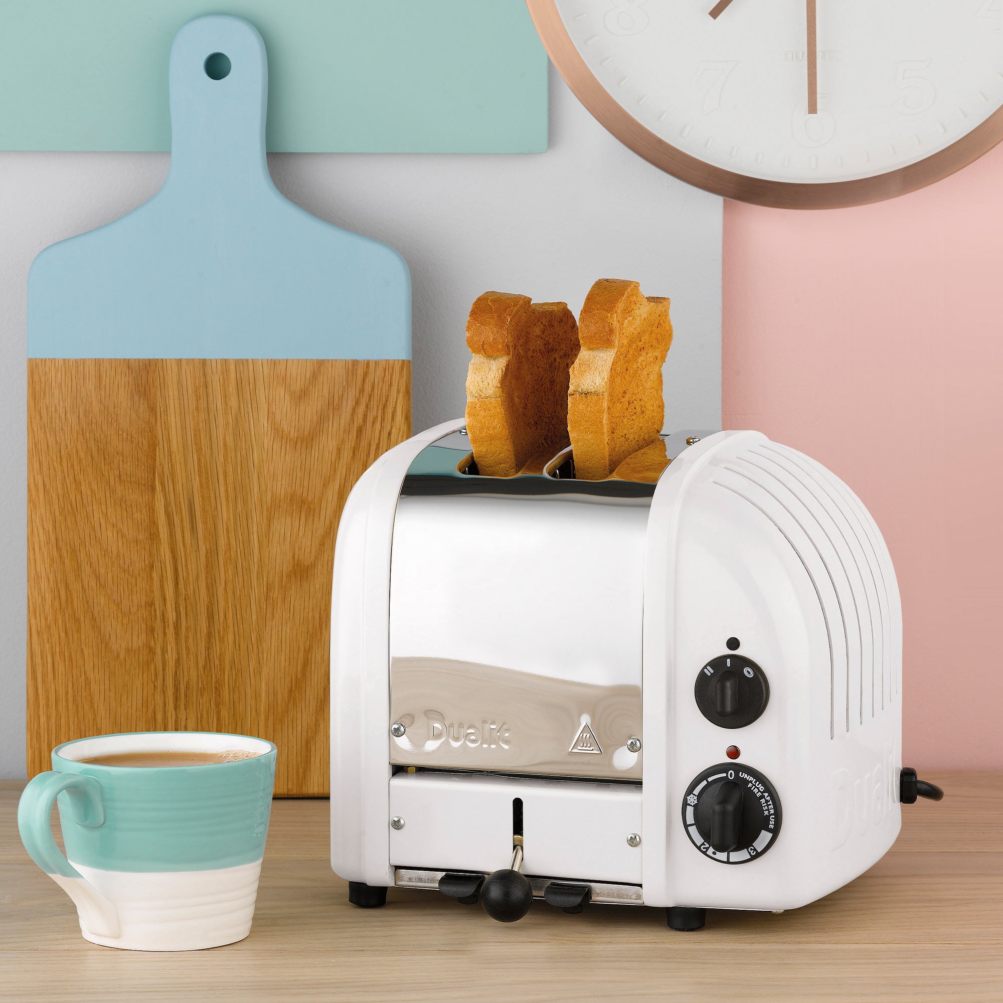 White 2-slice toaster with toast pieces in slots and side control dials