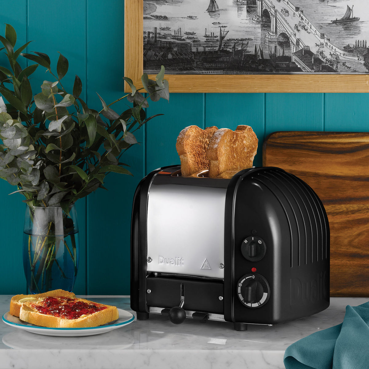 Matte black and silver 2-slice toaster with bread slices in the slots