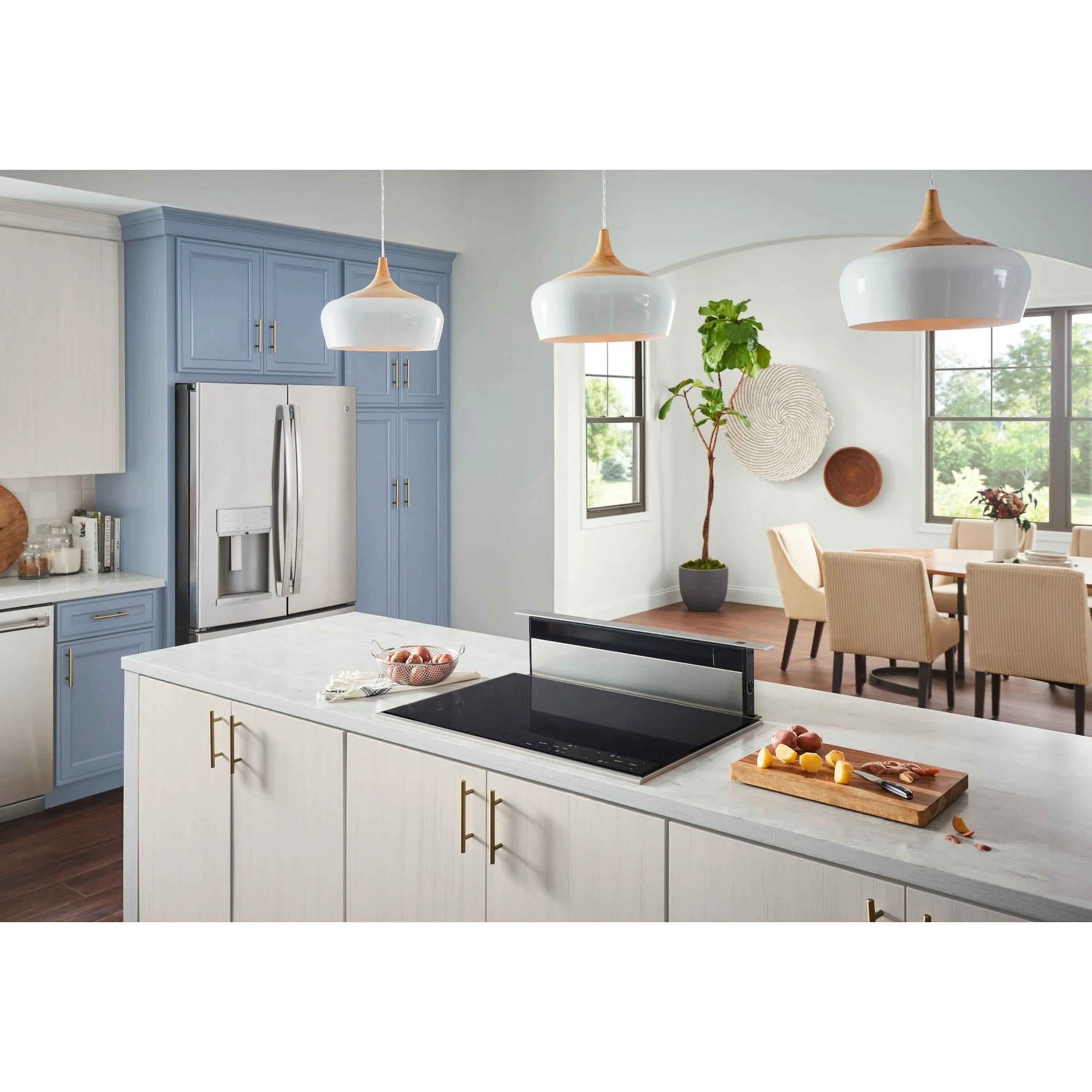 Downdraft range hood over black cooktop in a white kitchen with cabinets