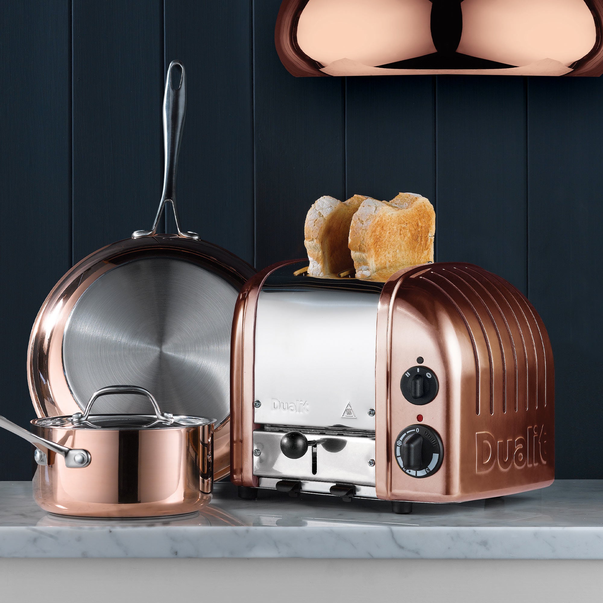 Copper Dualit 2-slice toaster with two bread slices inserted and dual control knobs