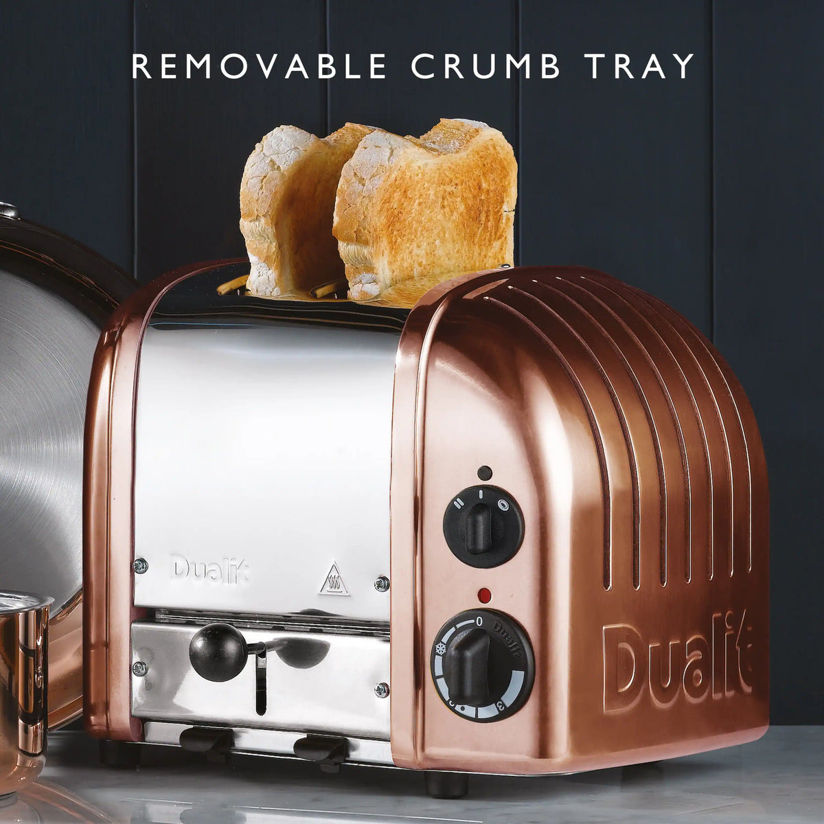 Copper 2-slice toaster with open crumb tray and two slices of bread