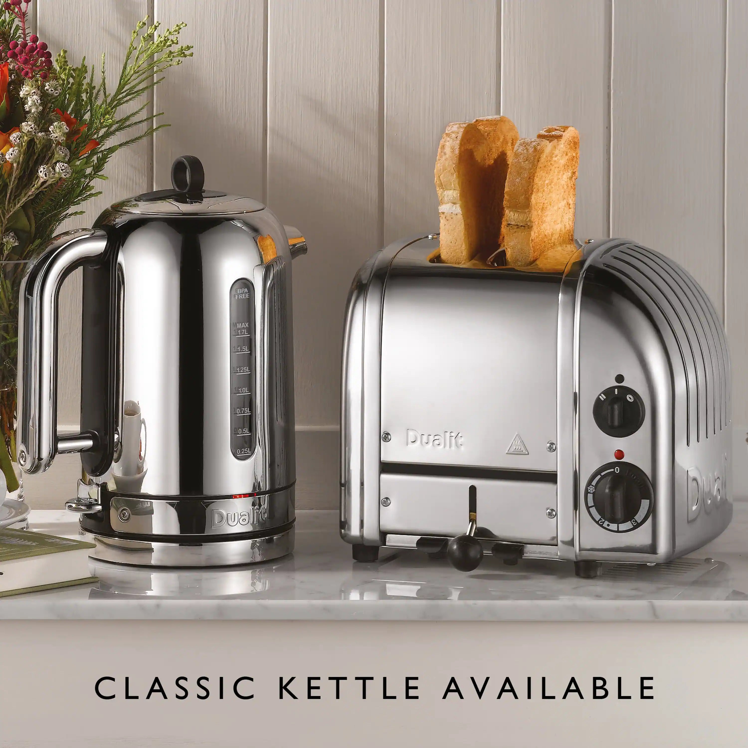 Chrome 2-slice toaster on countertop with bread slices in slots and two control dials
