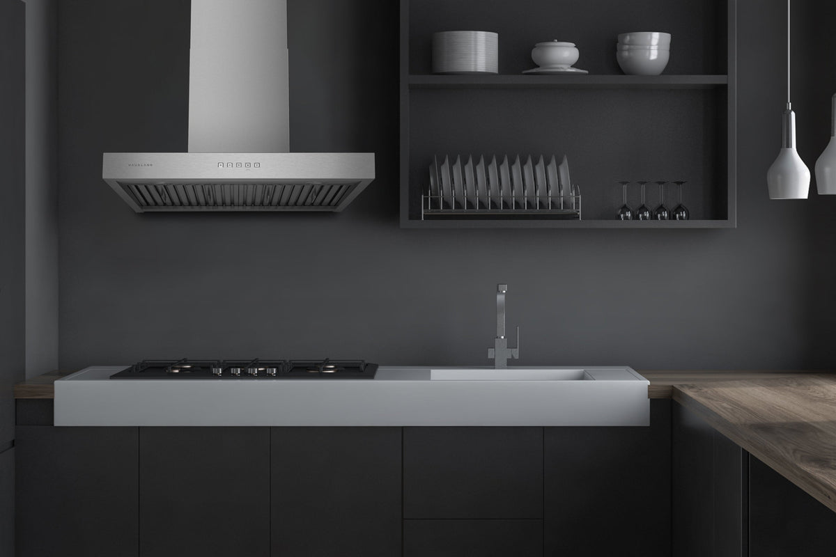 Stainless steel wall mount range hood over a cooktop with control strip along the front.