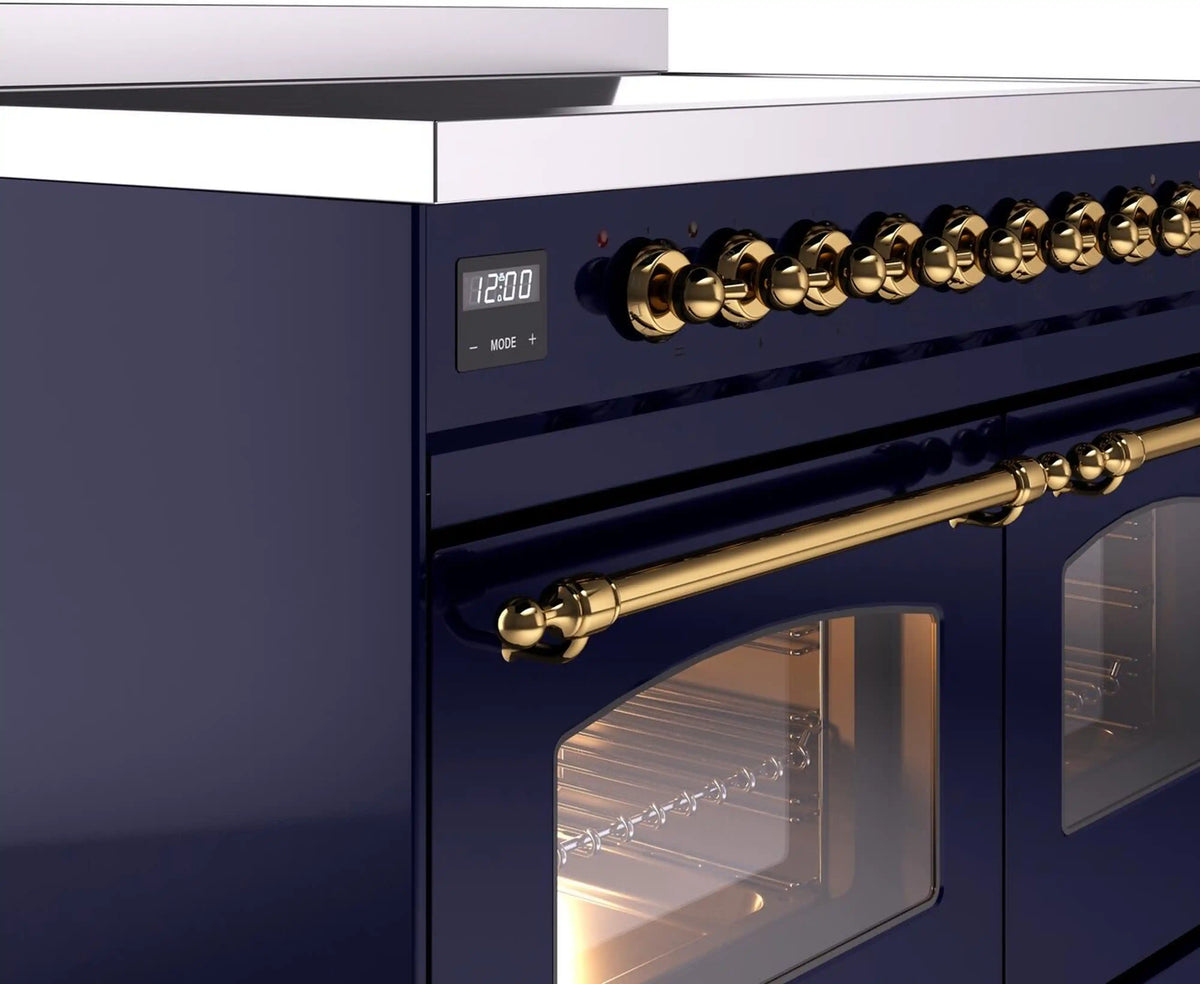 Brass control knobs and handle detail on a midnight blue freestanding electric induction range