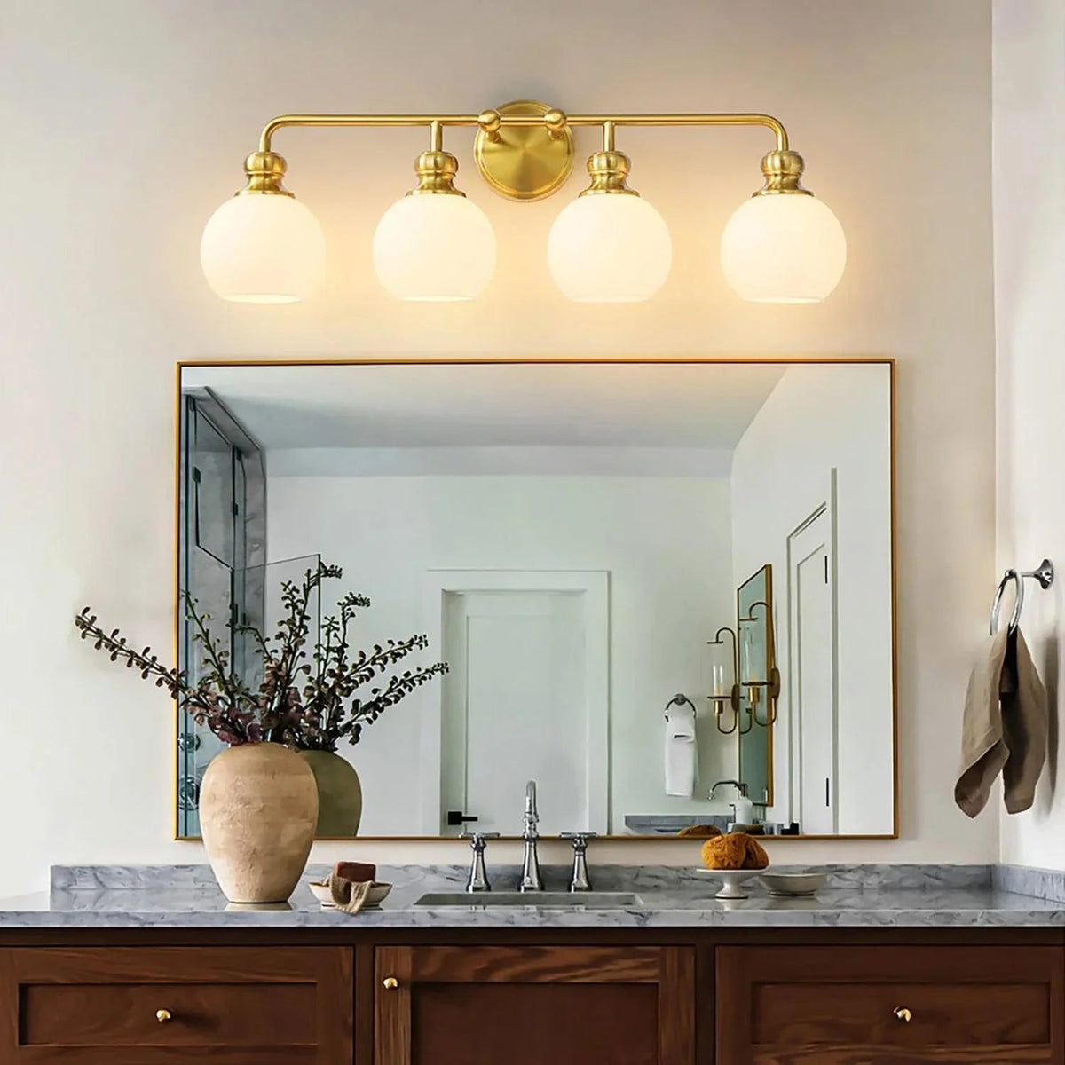 Golden 4-light vanity light with frosted glass globe shades