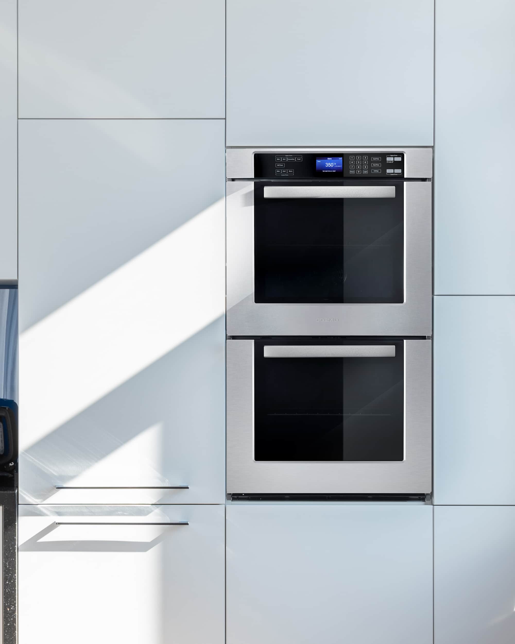 Stainless double wall oven in cabinet with two stacked black glass doors