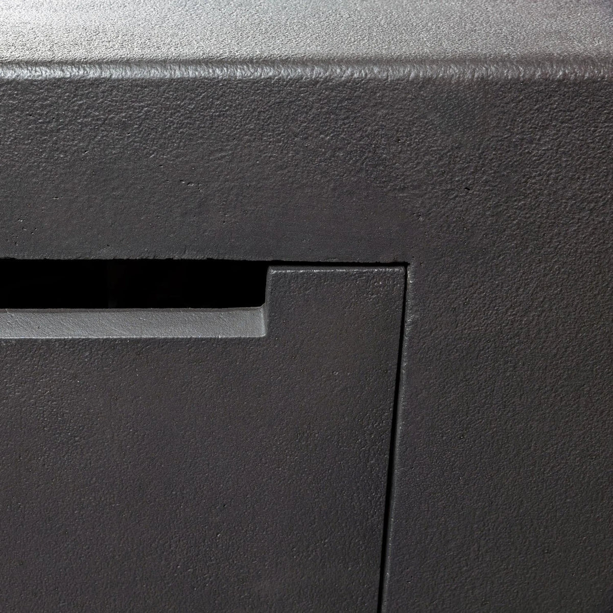 Dark concrete fire pit table corner with textured finish and recessed edge