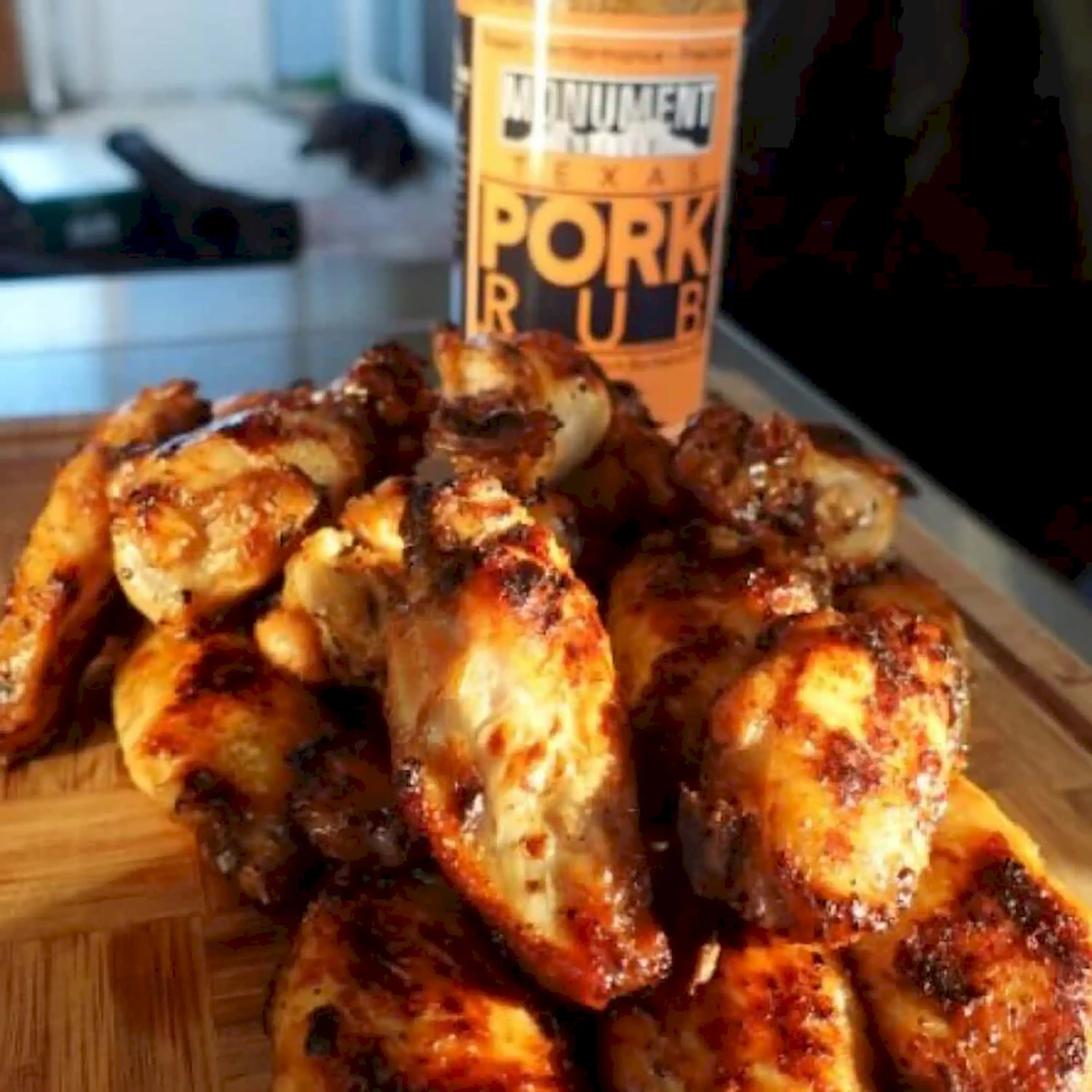 Glazed pork pieces on grill grate with browned, charred edges