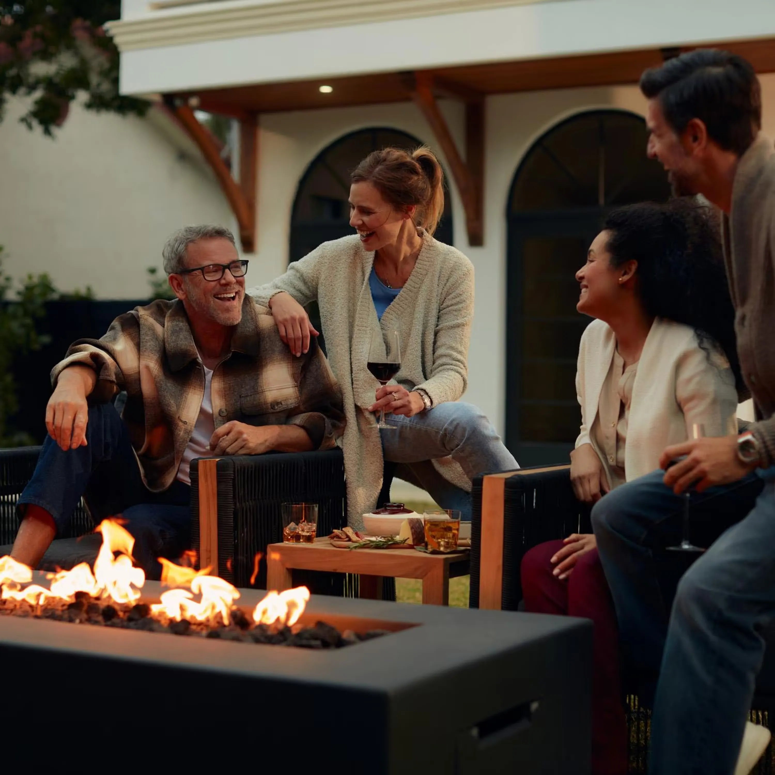 Rectangular gas fire pit table with visible flames in dark concrete top