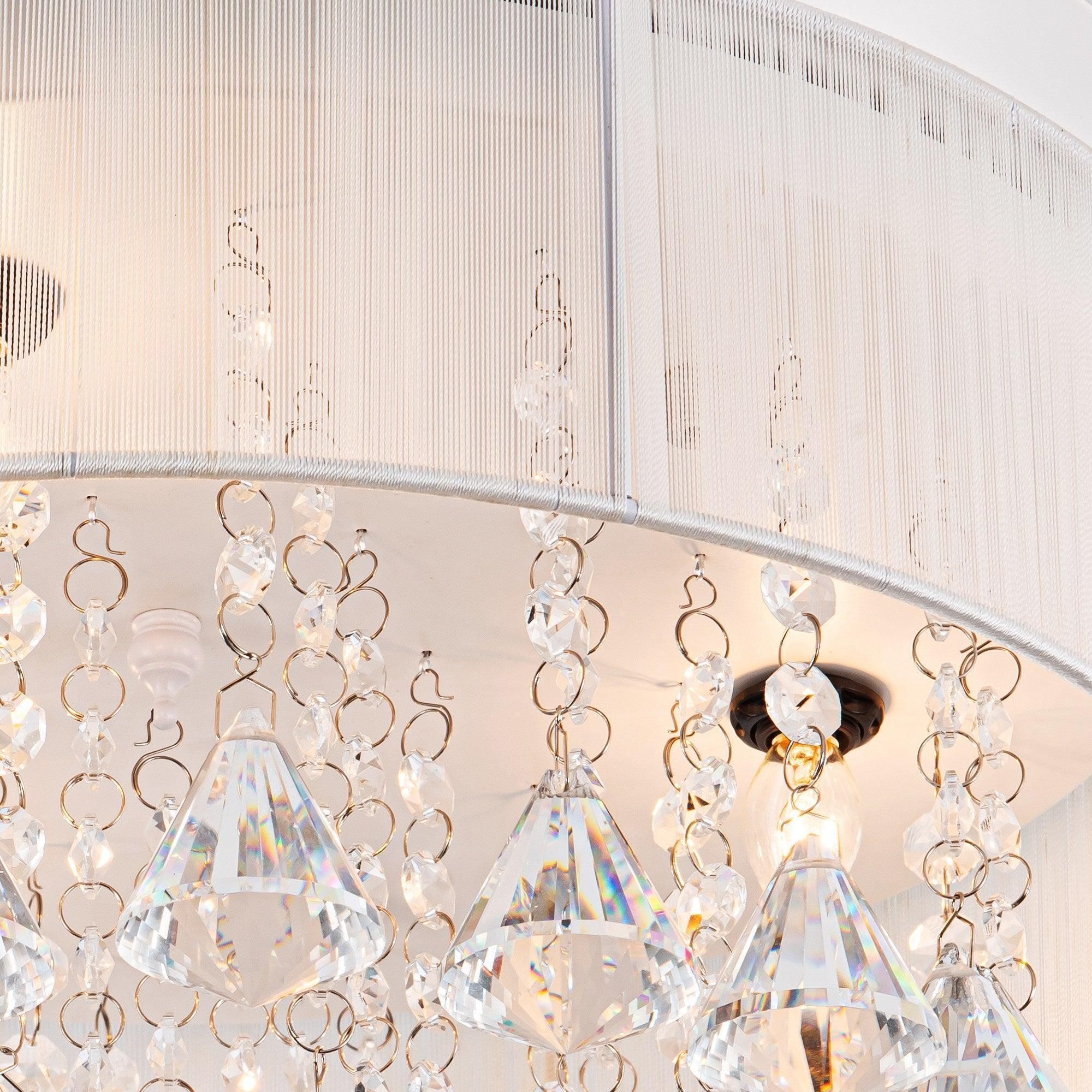 Close-up of crystal prisms and metal rings under ceiling fan light shade