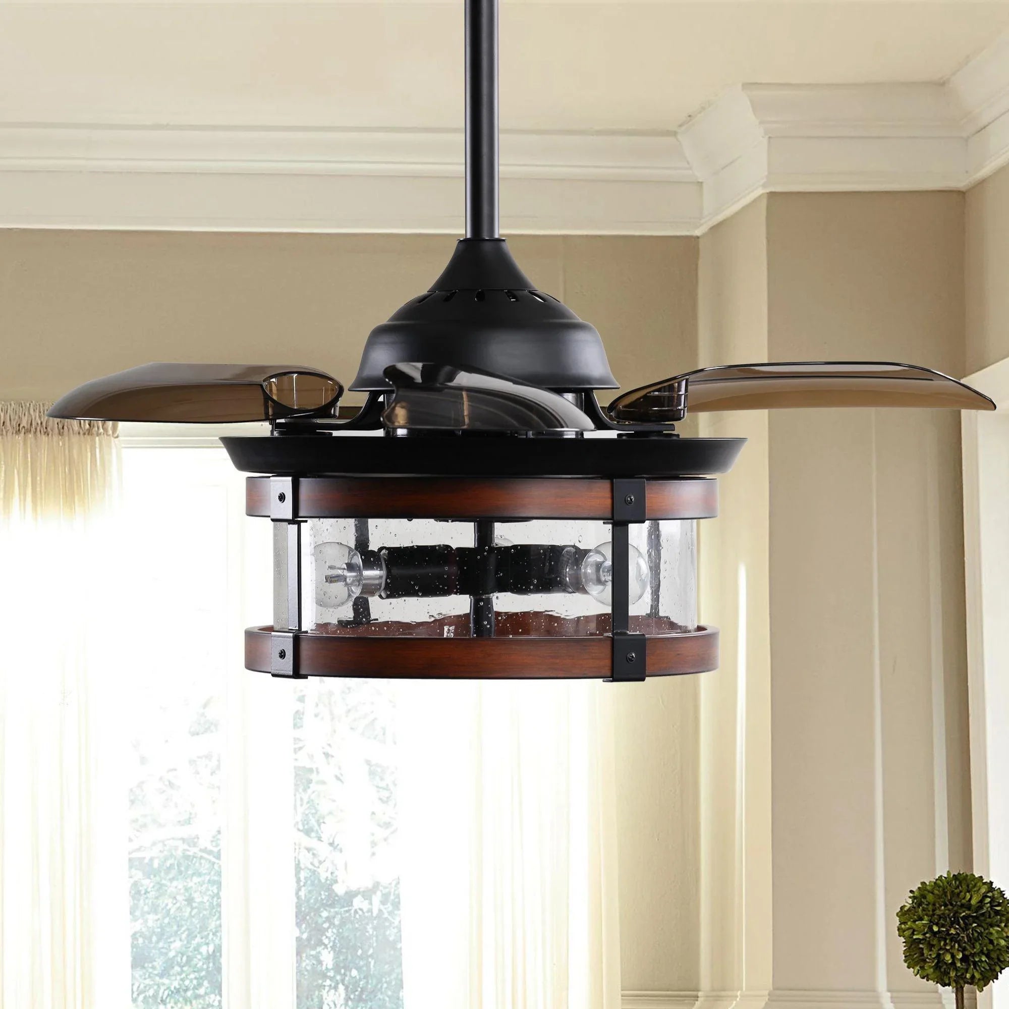 Black ceiling fan with wood-toned blades and clear glass light enclosure.