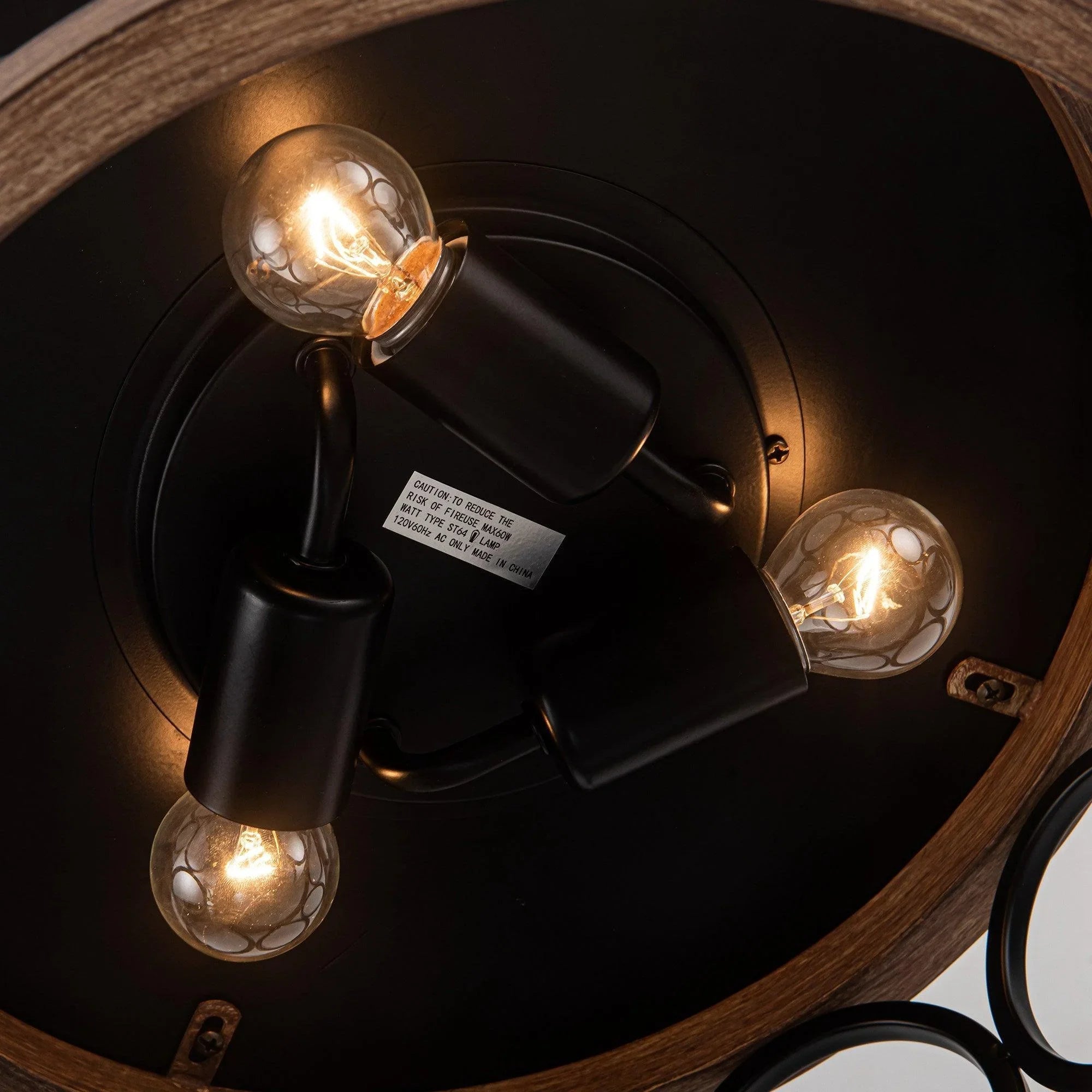 Black ceiling fan motor housing with three glowing bulbs and mounting hardware