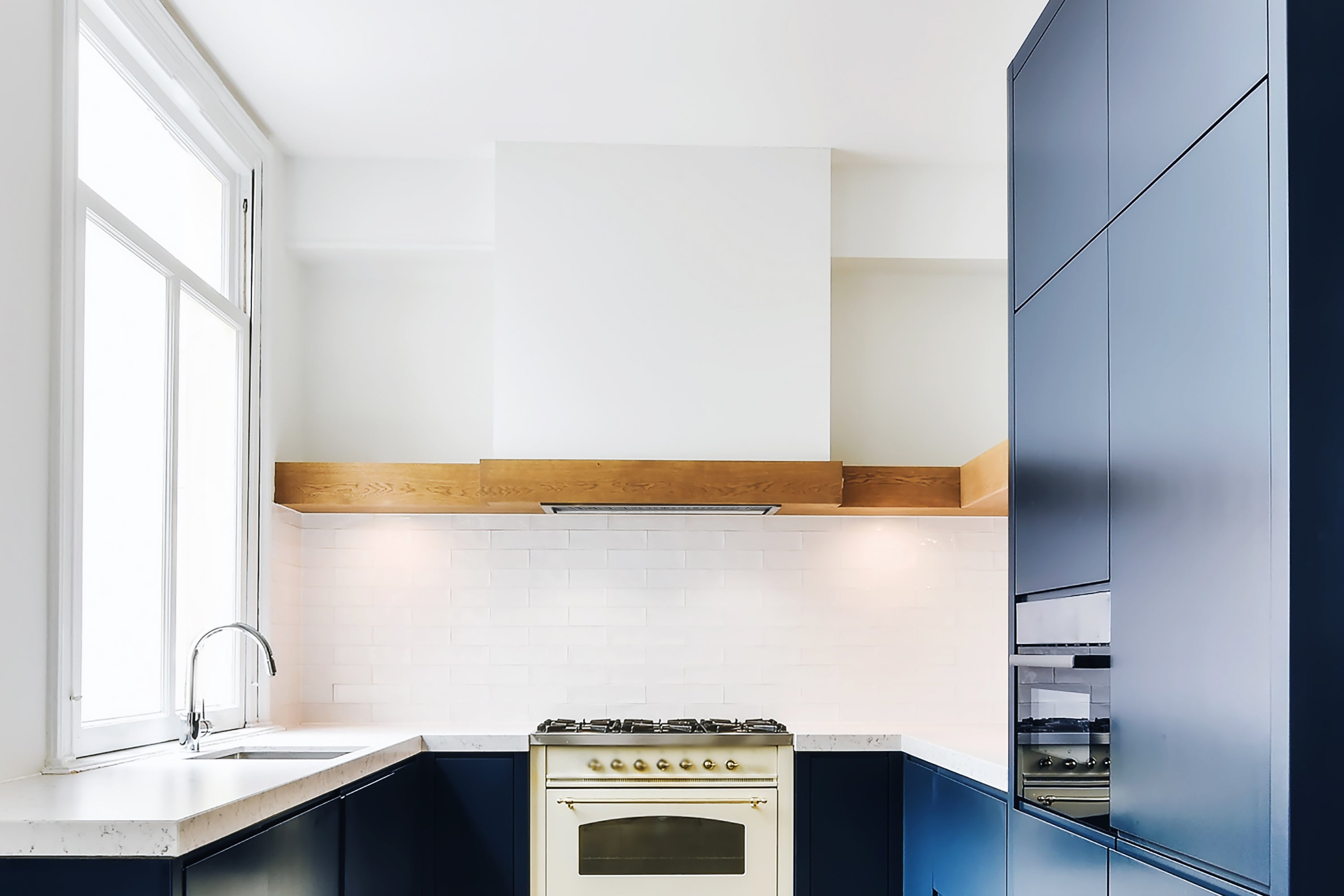 Stainless steel convertible built-in range hood insert above a cooktop