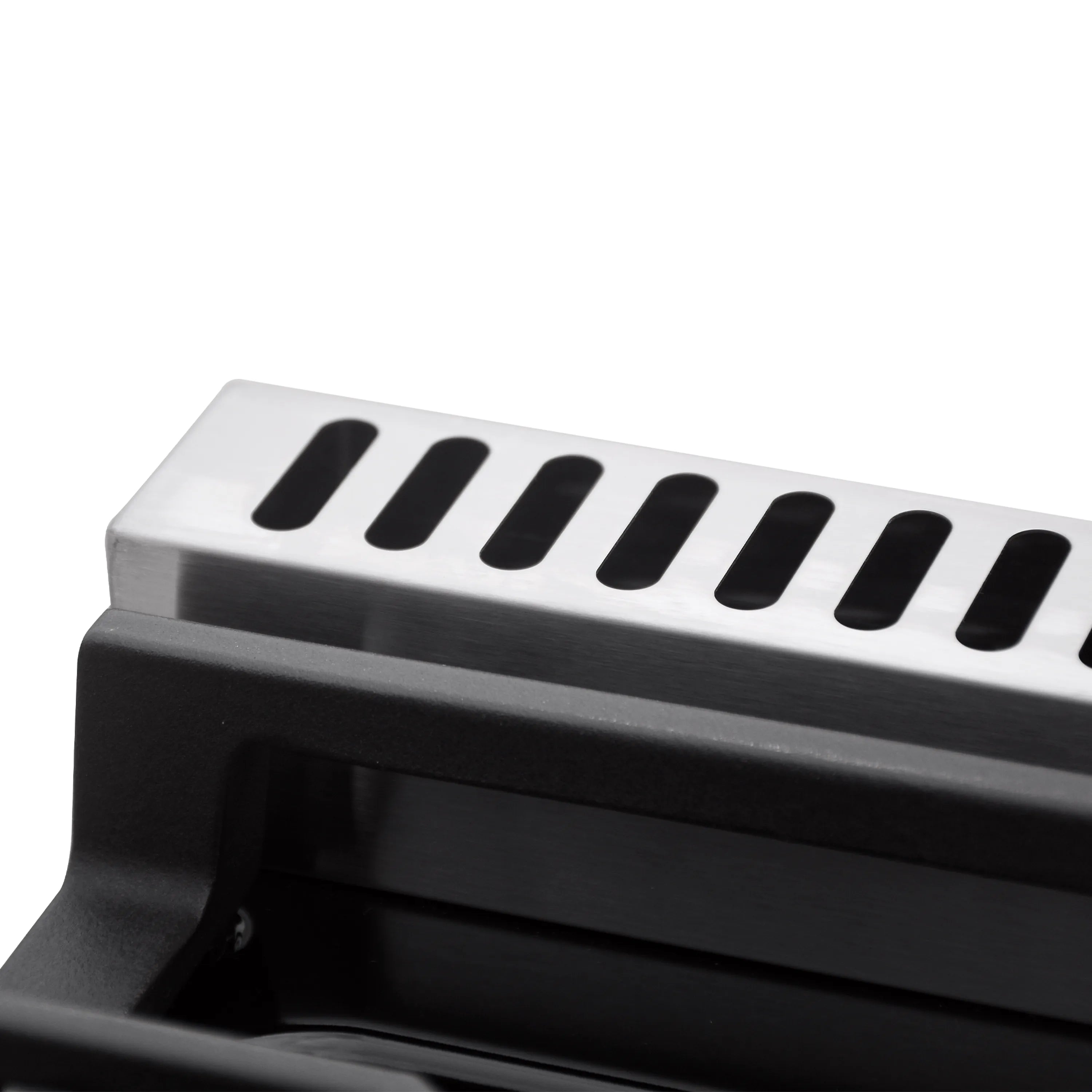 Gas range burner cap and black cooktop vent slots along the front edge