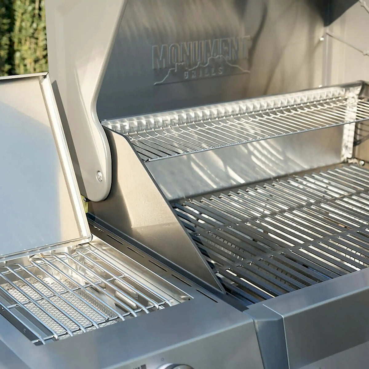 Open propane grill showing upper and lower stainless steel cooking grates