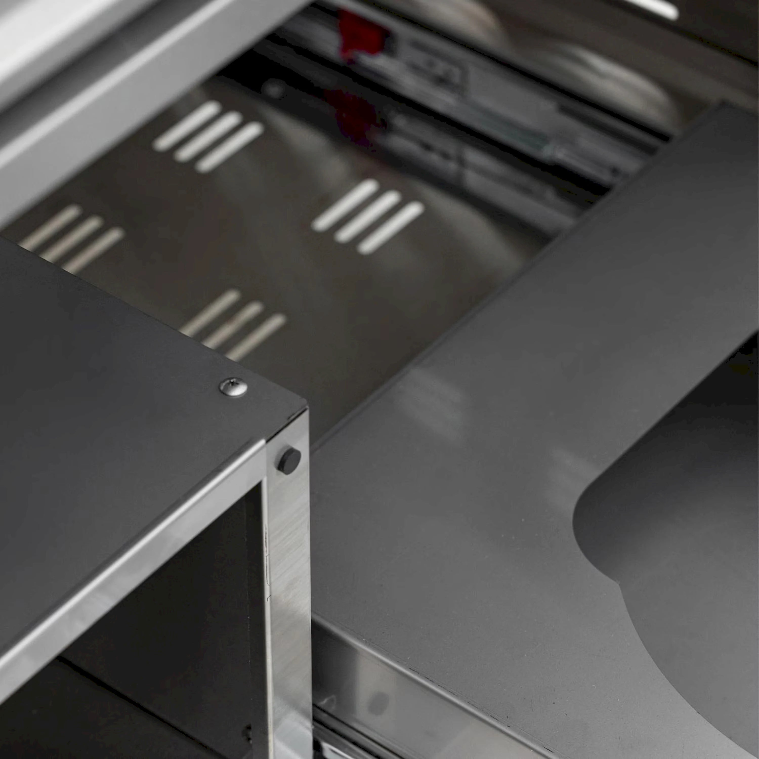 Stainless griddle burner area with vent holes and metal heat zone plates