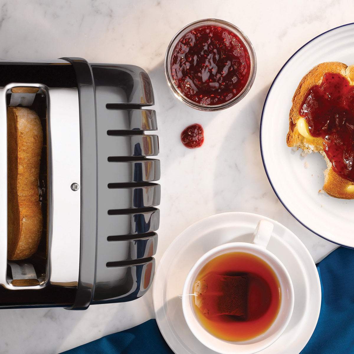 Dualit 4-slice toaster in metallic charcoal, with toast slots and toast rising
