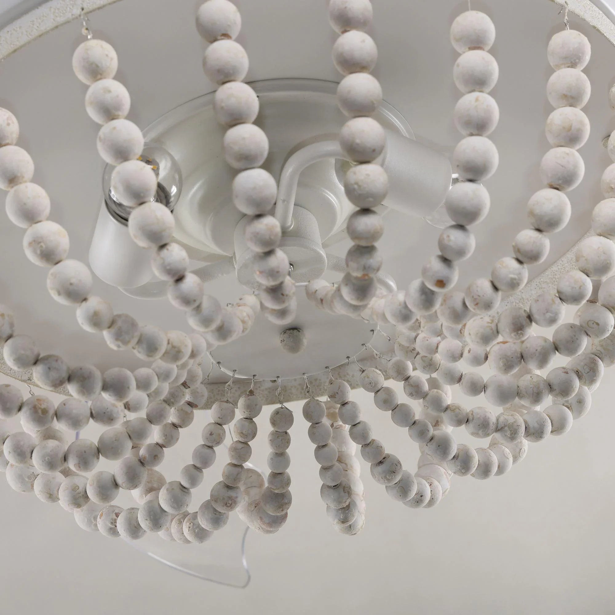 Close-up of beaded globe ceiling fan with white wooden ball clusters around lights