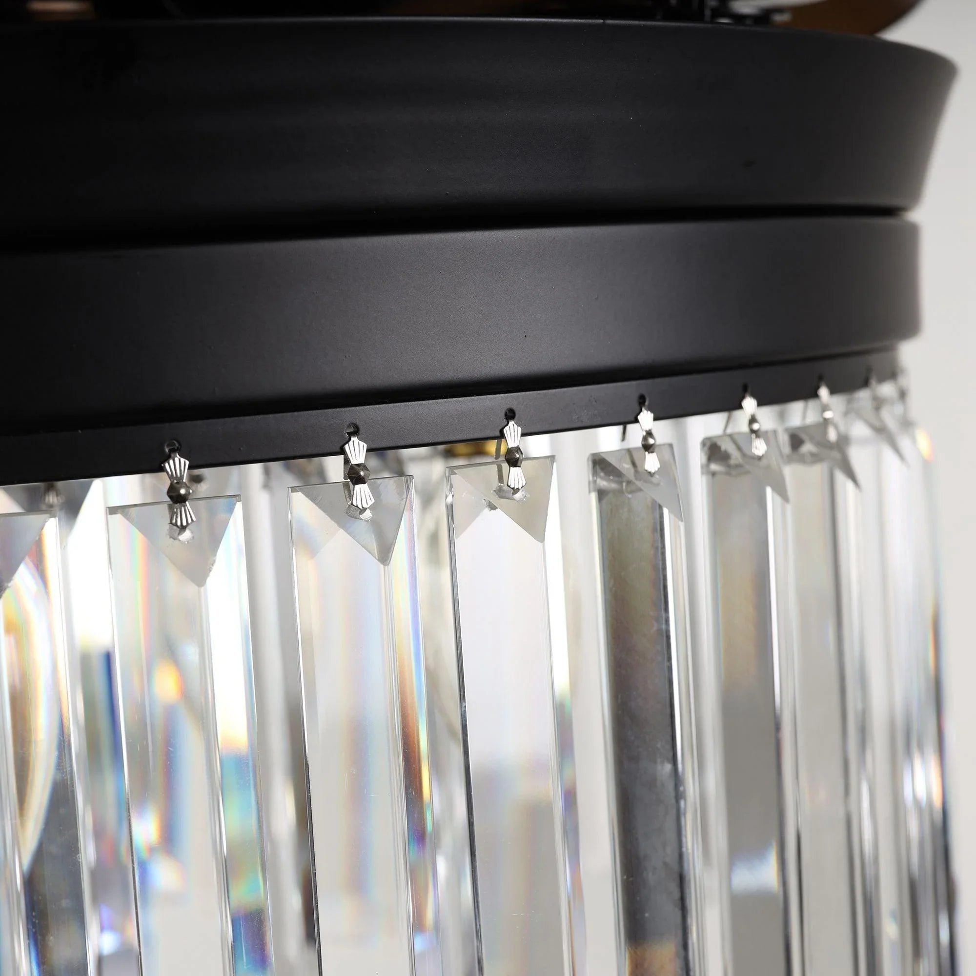 Crystal glass light fixture with vertical prism panels on a black ceiling fan