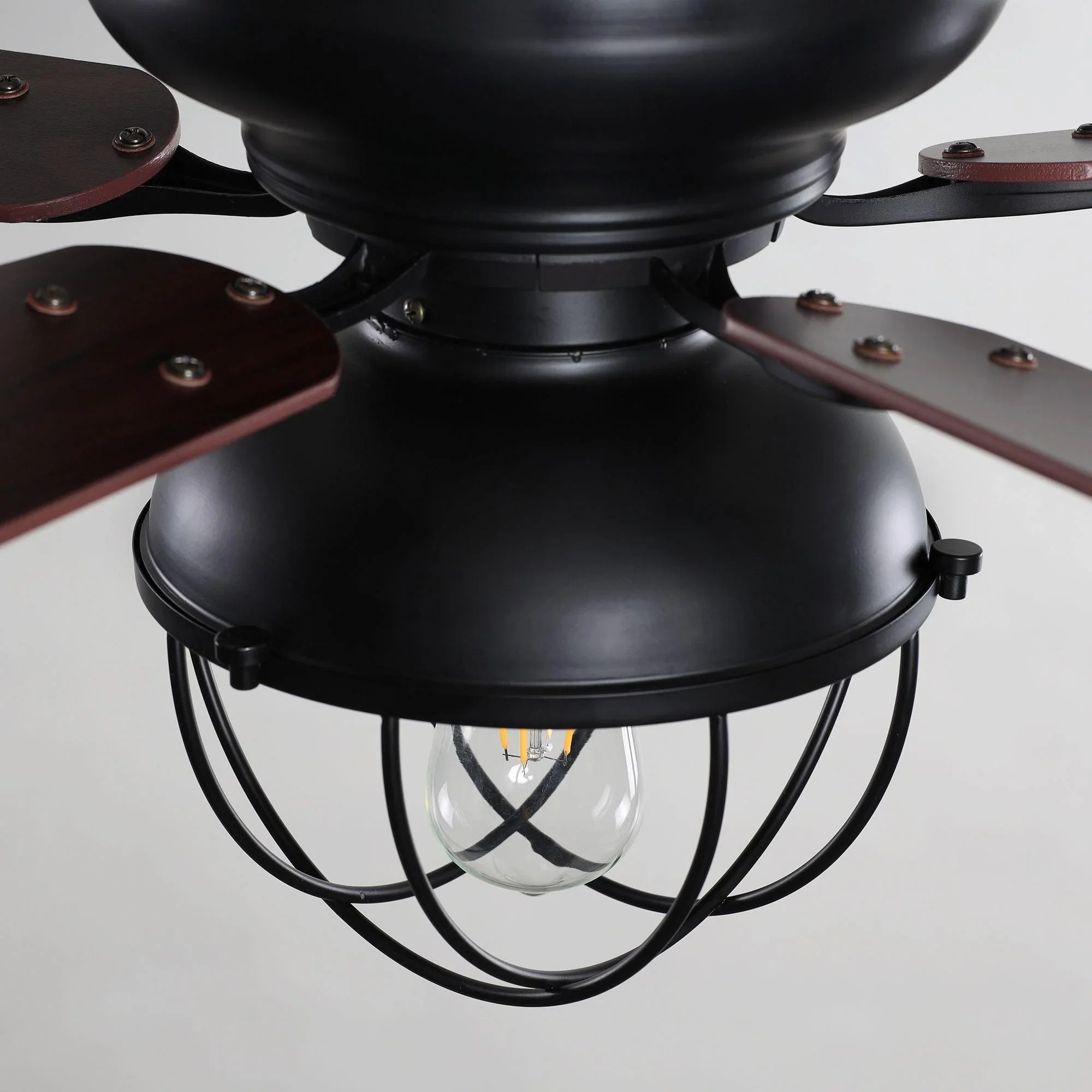Close-up of black flush-mount ceiling fan housing with lantern light and wiring