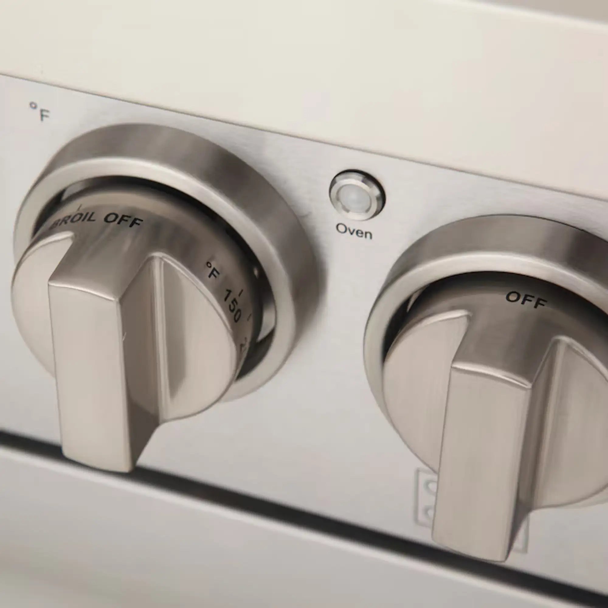 Light blue gas range control panel with two silver burner knobs and one oven knob