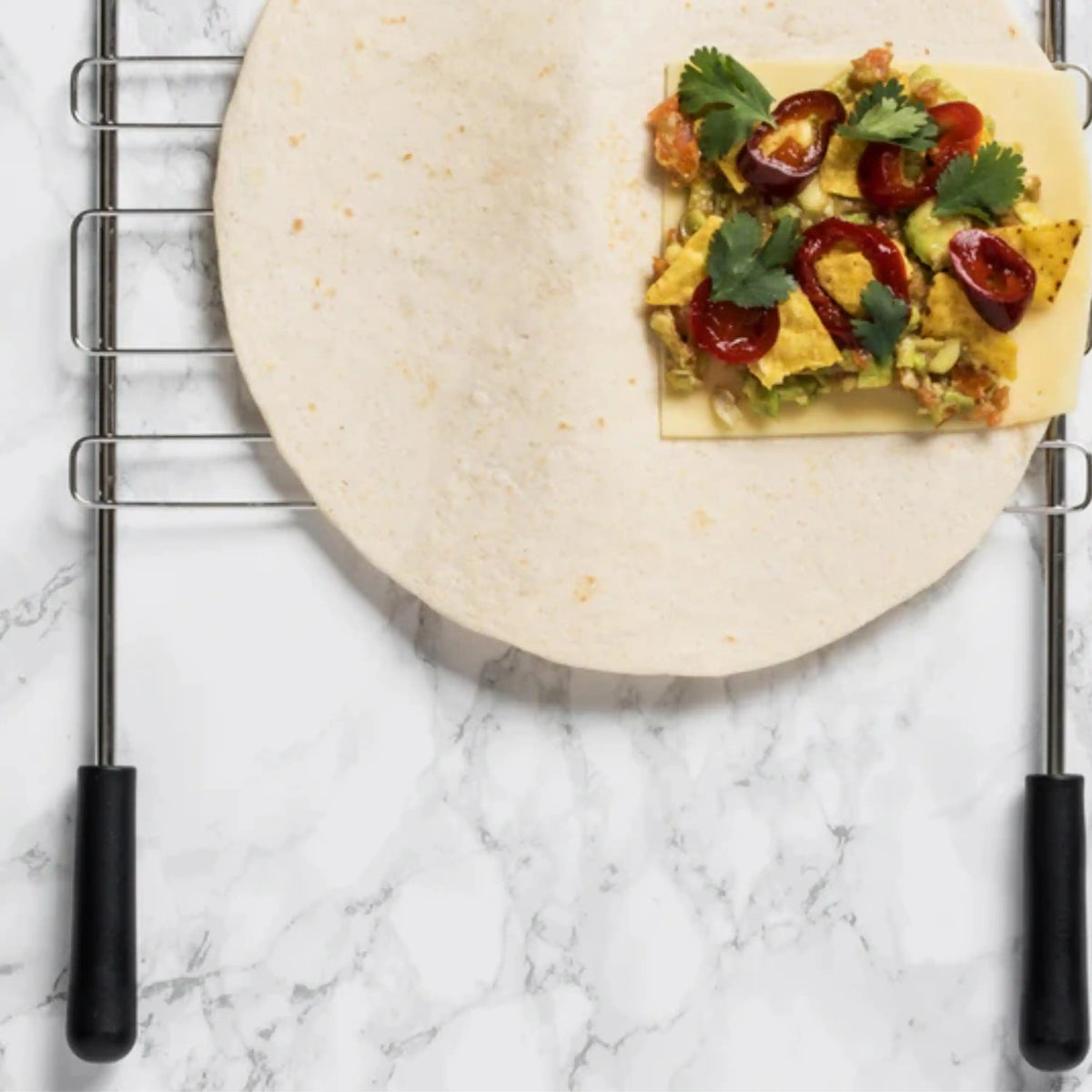Sandwich cage toaster rack showing flat food with greens and tomatoes on plate