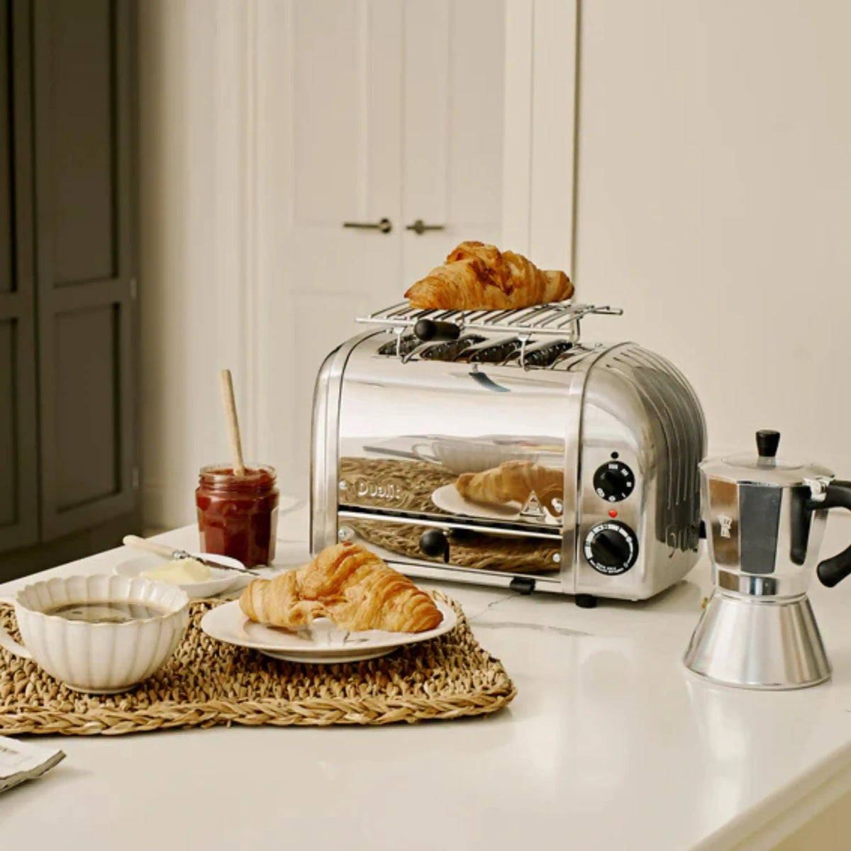 Stainless warming rack on countertop toaster with pastries inside